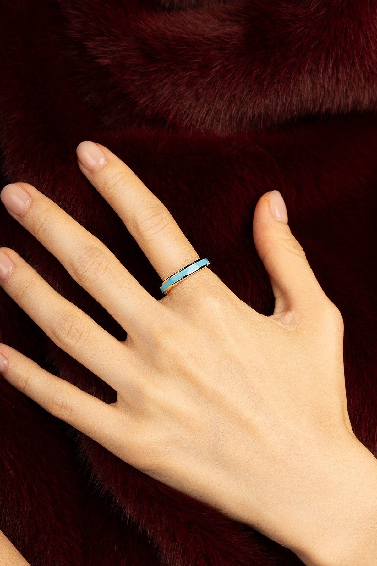 Woman wearing APM Monaco ring, a turquoise whisper of quiet winter elegance.