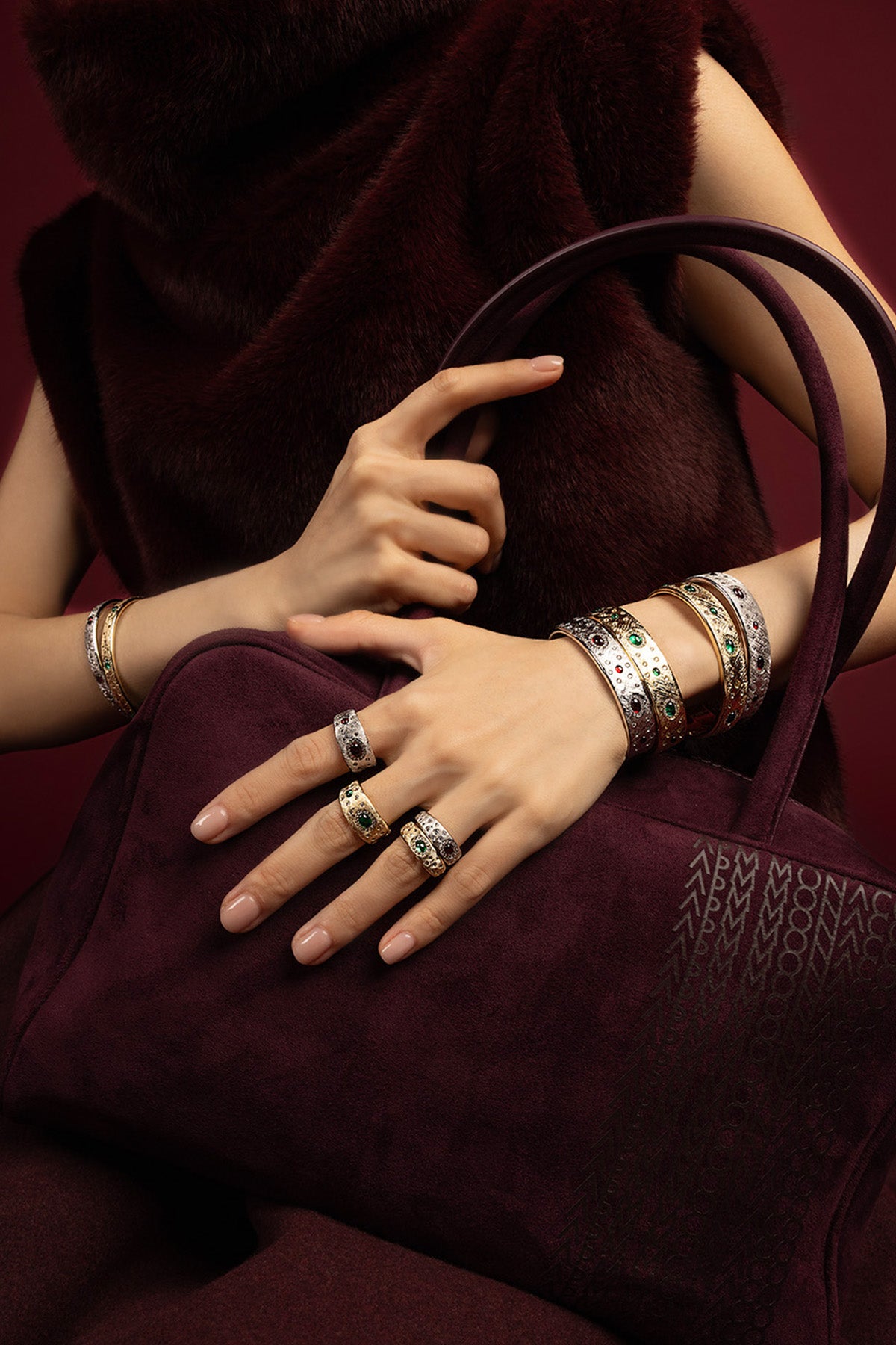 Woman wearing APM stacked bangles and rings, a rich winter statement in bold color.