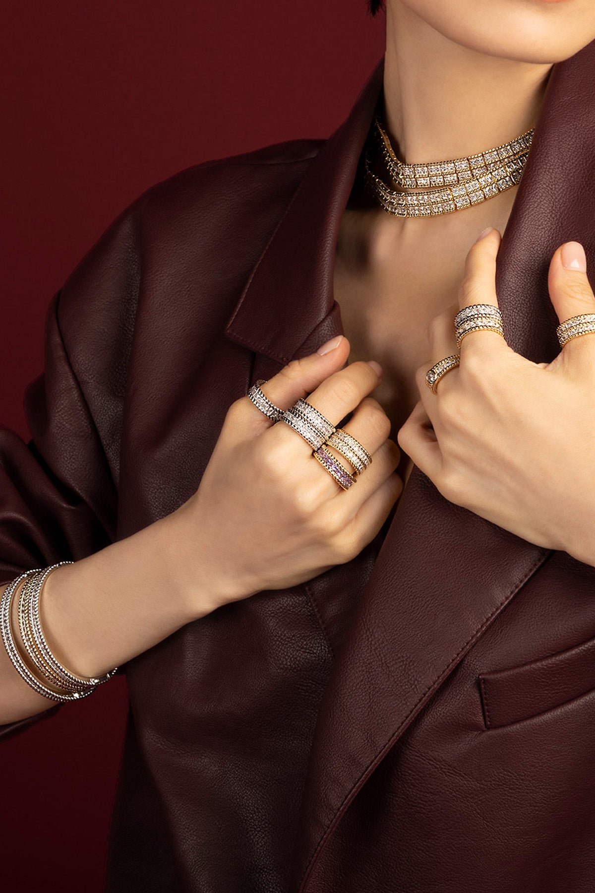 Woman wearing APM Monaco stacked jewelry set, bold shimmer meets burgundy allure.