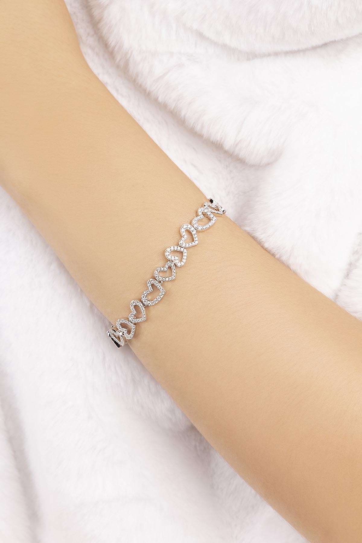 APM MONACO heart-shaped bracelet in silver wearing on wrist