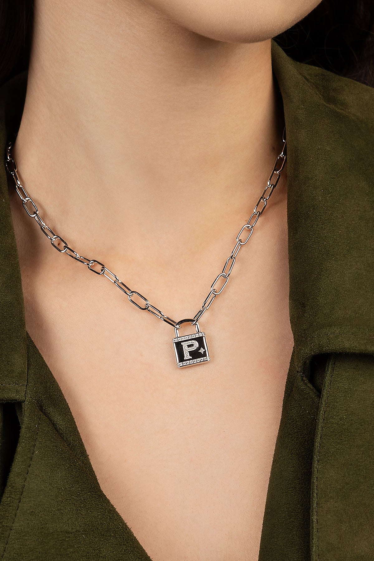 Necklace with a square pendant featuring a letter 'P' on a person wearing a green shirt.