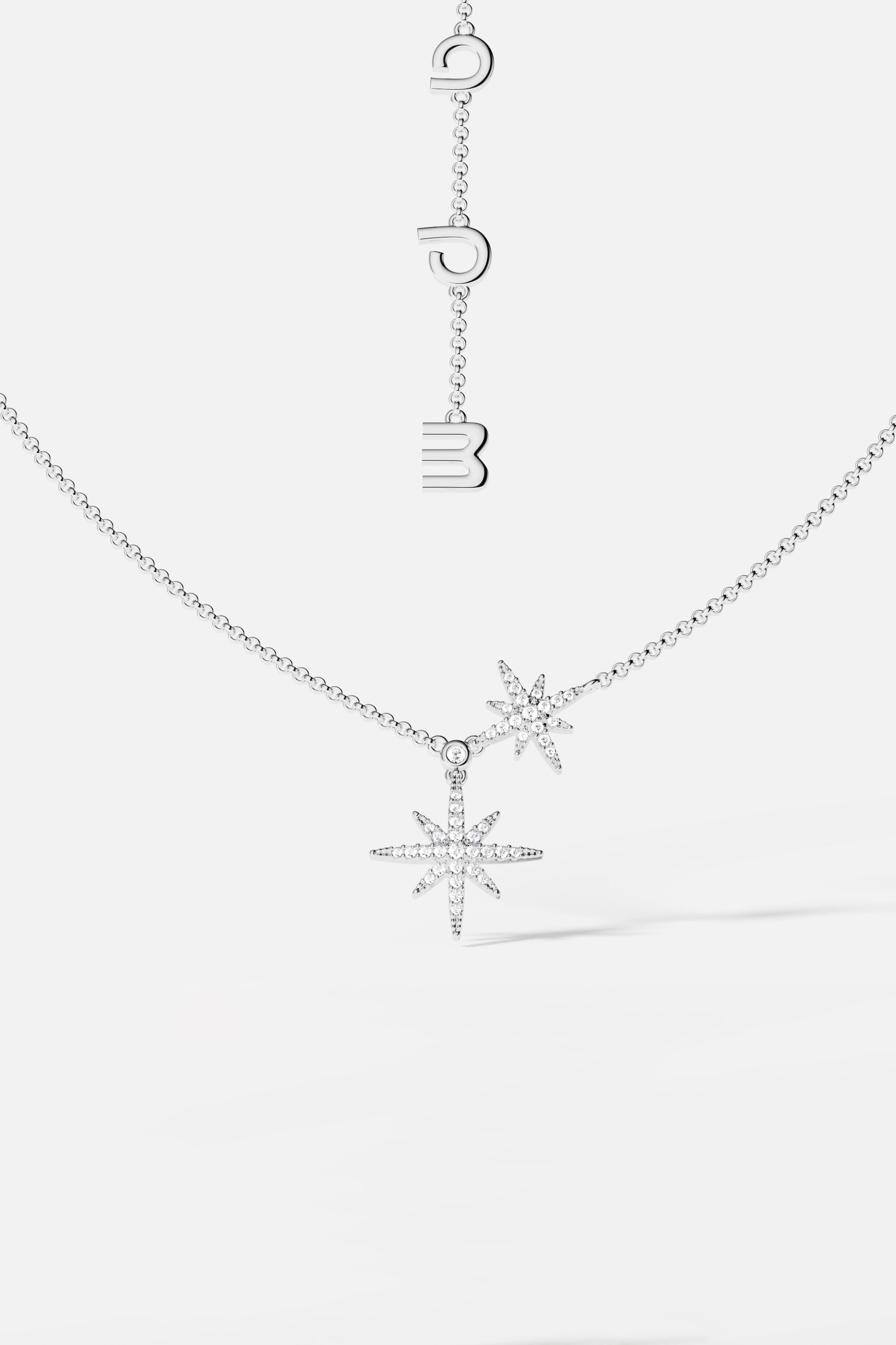 Necklaces APM Monaco, a silver-tone necklace with two star-shaped charms encrusted with small gems on a delicate chain.