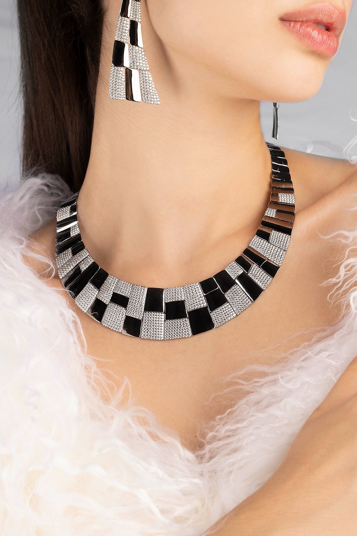 Necklace and earrings with geometric pattern worn by a model