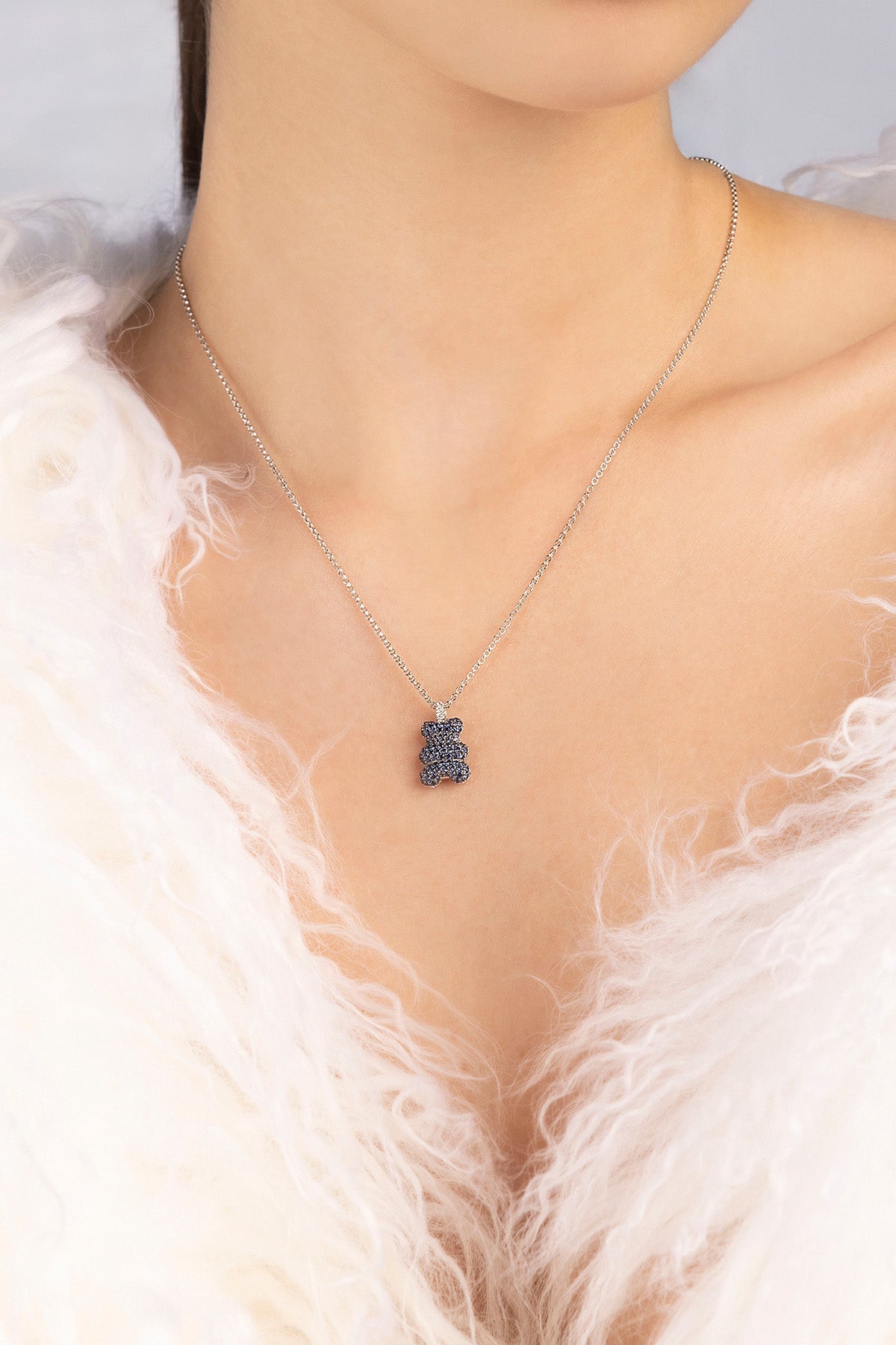 APM MONACO adjustable necklace with a baby yummy bear pendant on a model wearing a white fur garment