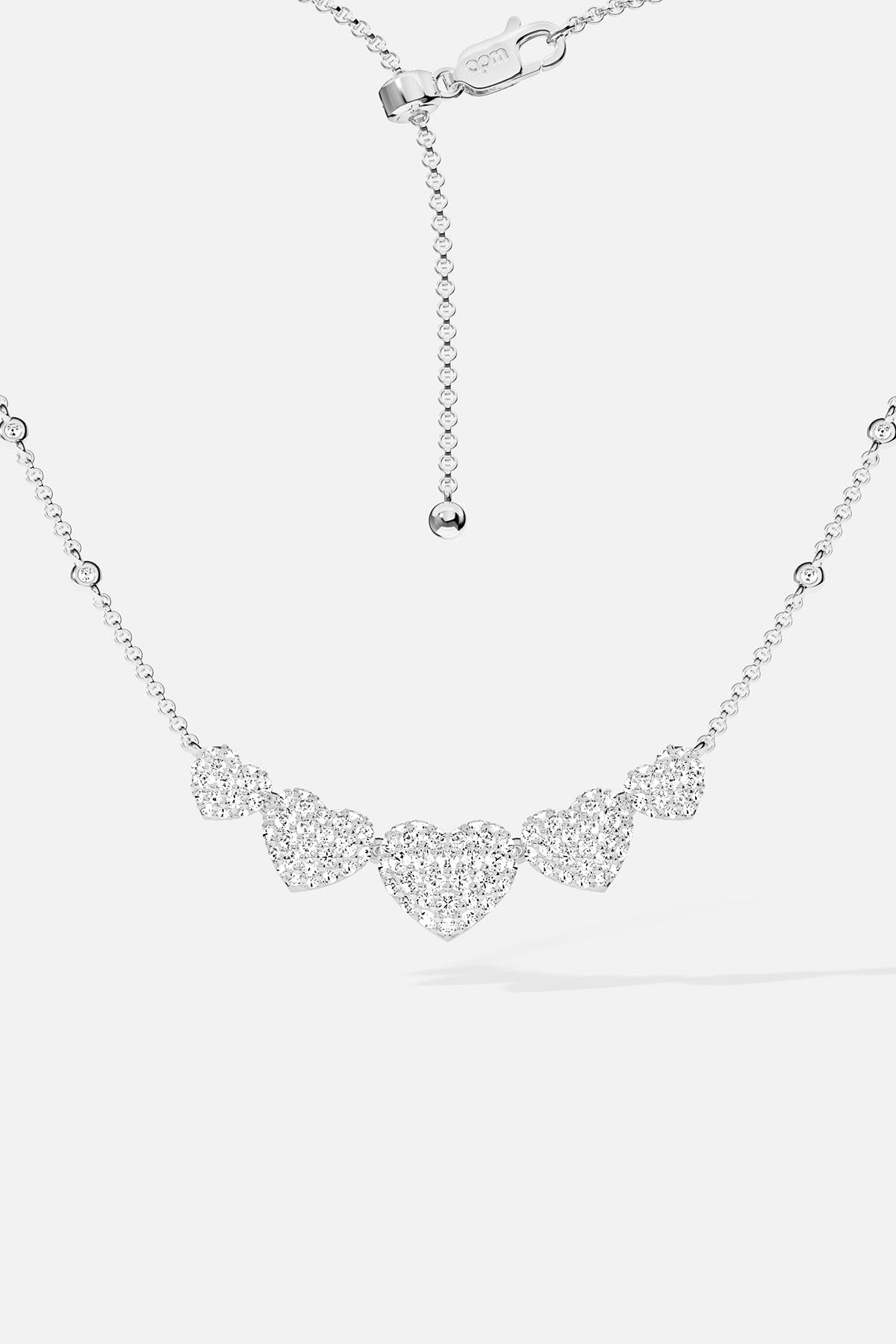 APM MONACO silver necklace with five heart-shaped pendants design on a white background