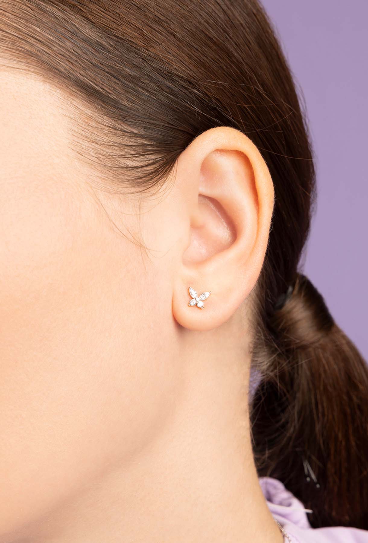 Close-up of an ear wearing a small earring with a blurred background