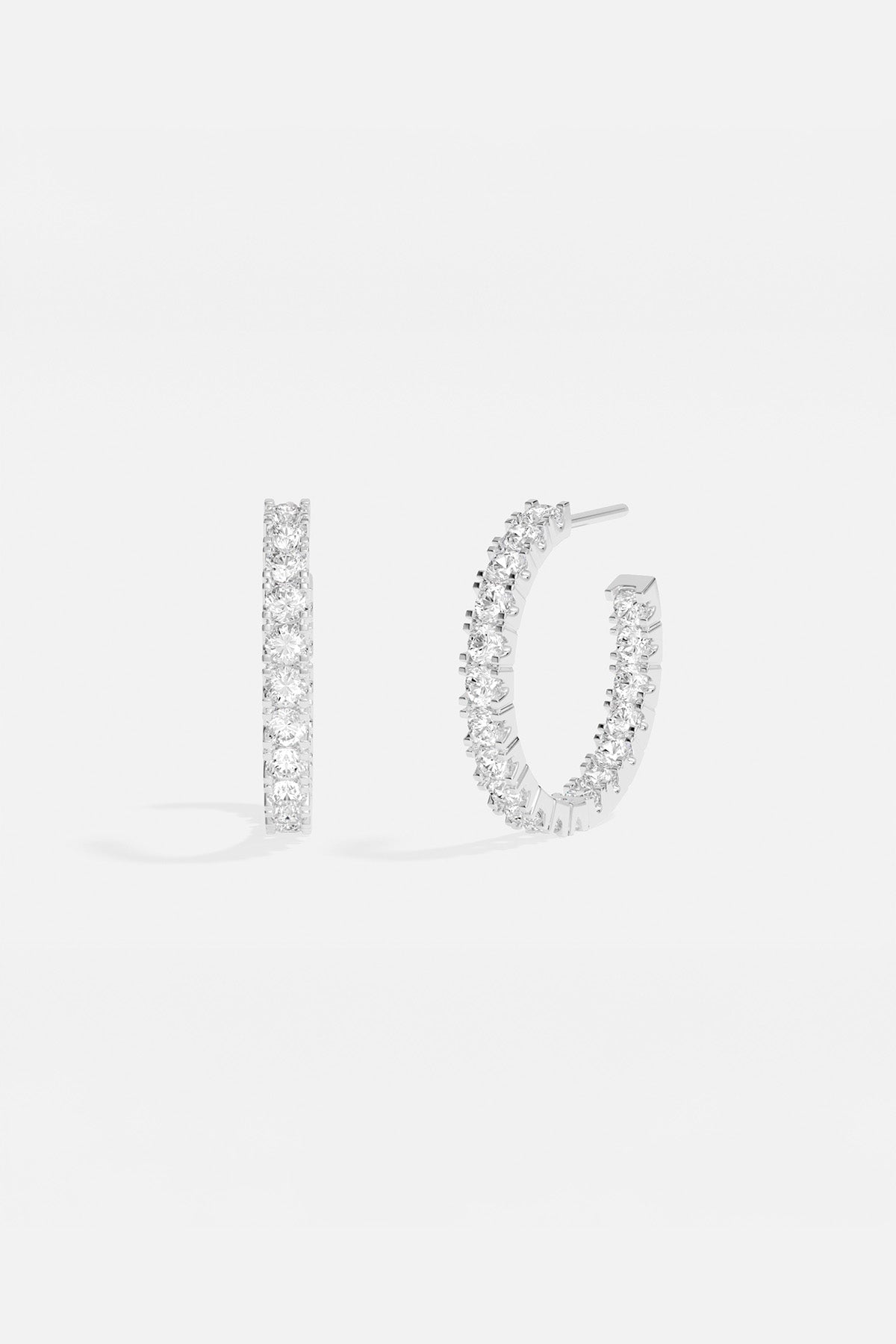 Earrings APM Monaco pavé hoop earrings in white silver-tone metal with clear stones.