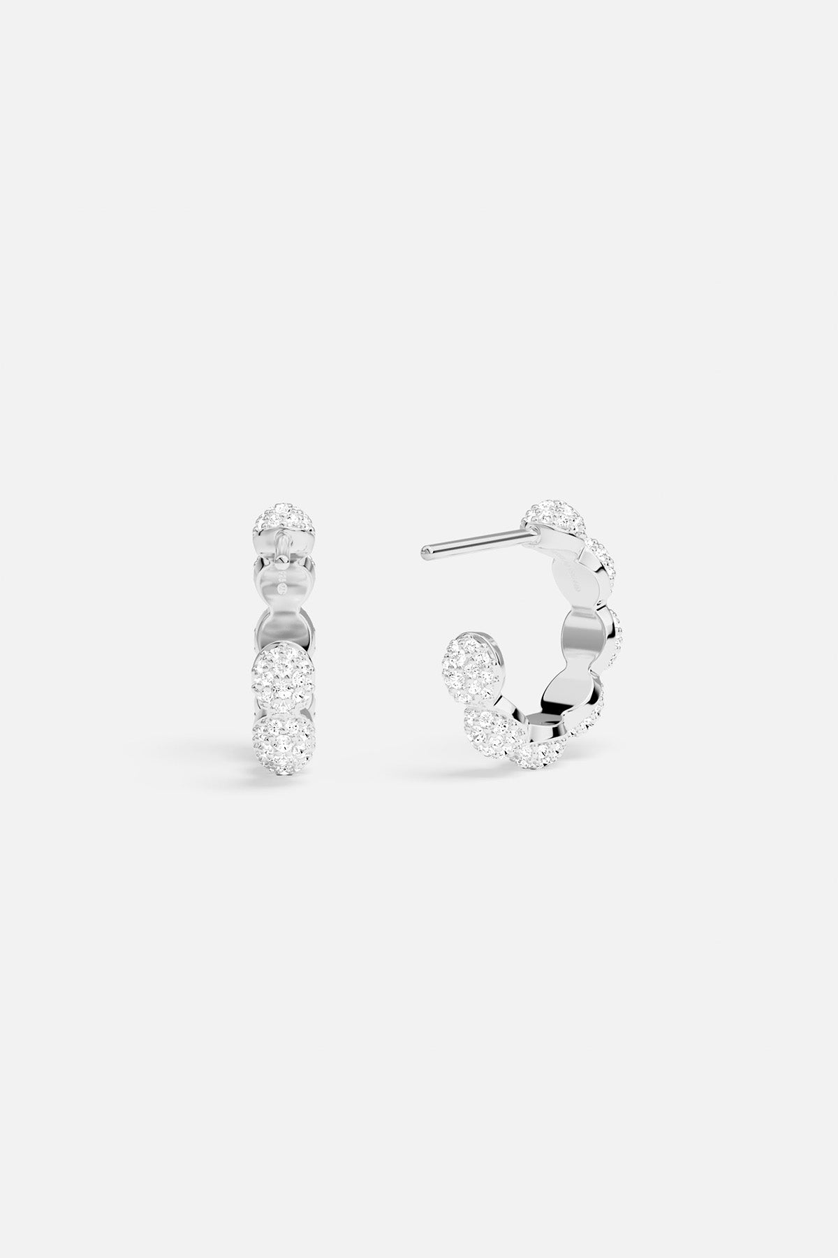 Silver hoop earrings with clear gemstones on a white background