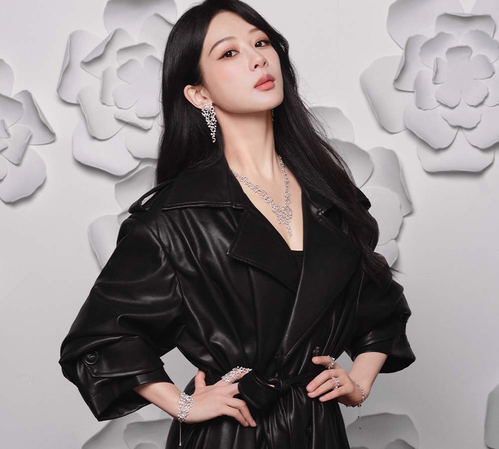Woman wearing a black leather jacket with pavé floral drop earrings and necklace