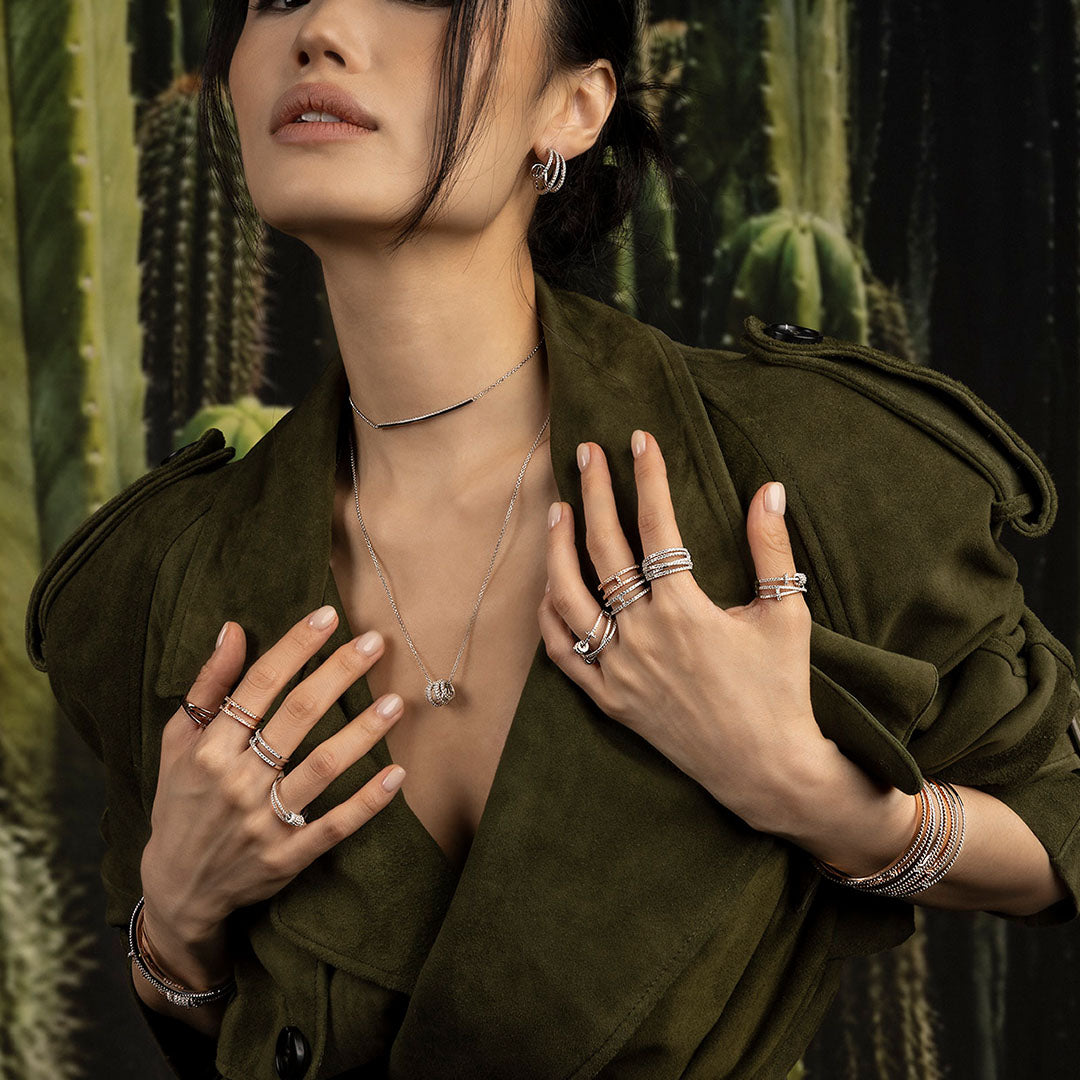 Woman wearing multiple jewelry from APM MONACO Croisette collection with cacti in the background