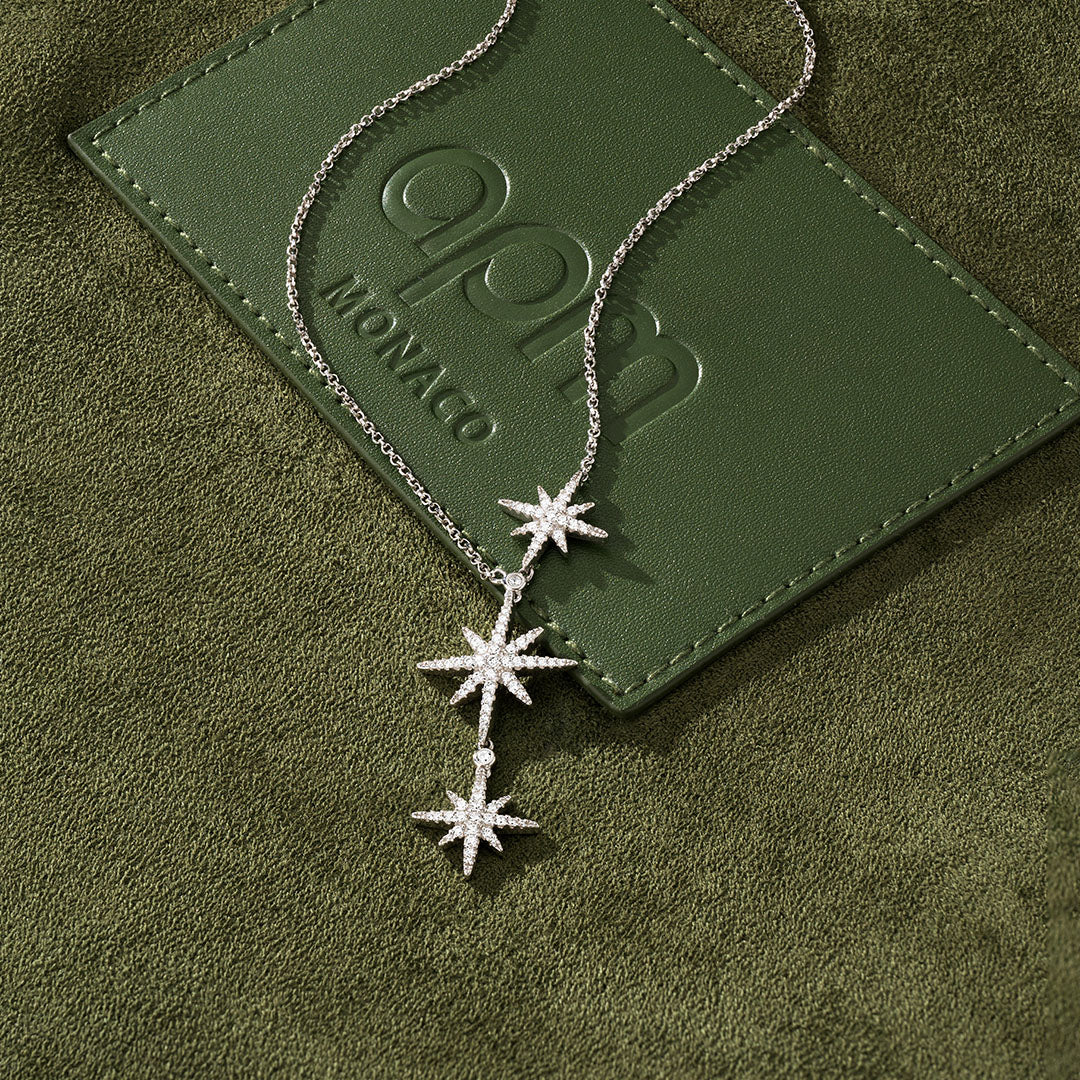 APM MONACO star-shaped necklace on a green textured surface