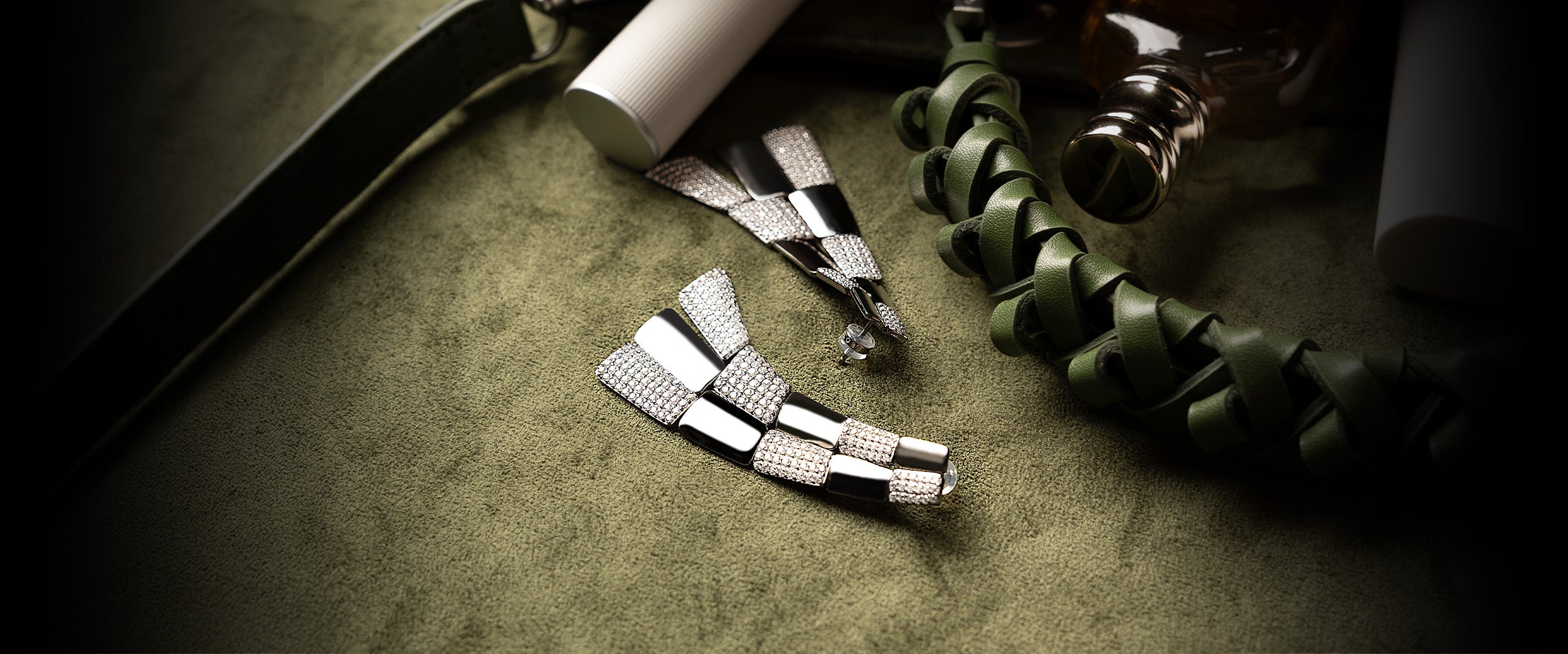APM MONACO pave statement earrings on khaki textured surface