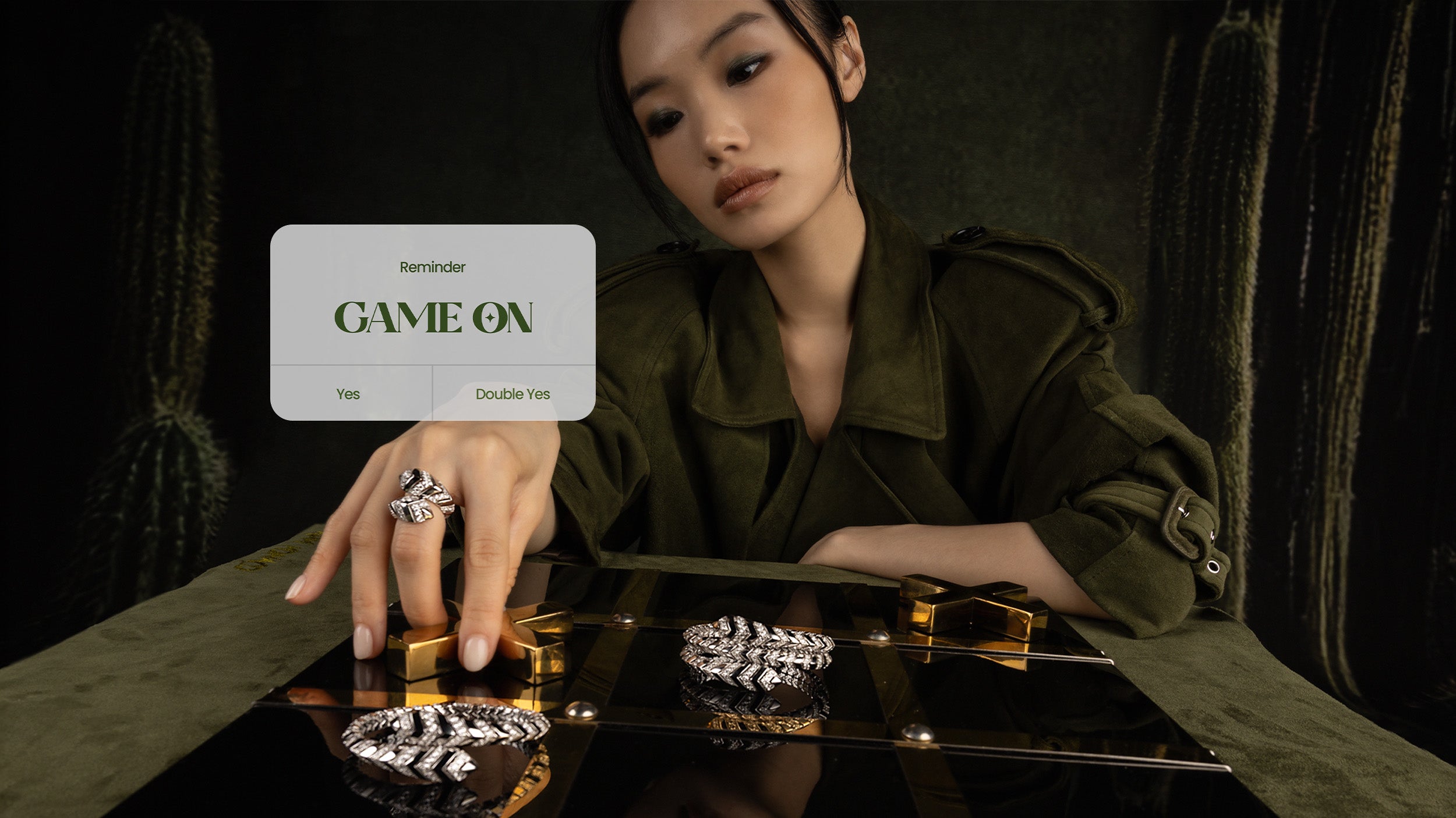 Woman holding APM MONACO KAA bangles and rings with a 'Game On' pop up in the background