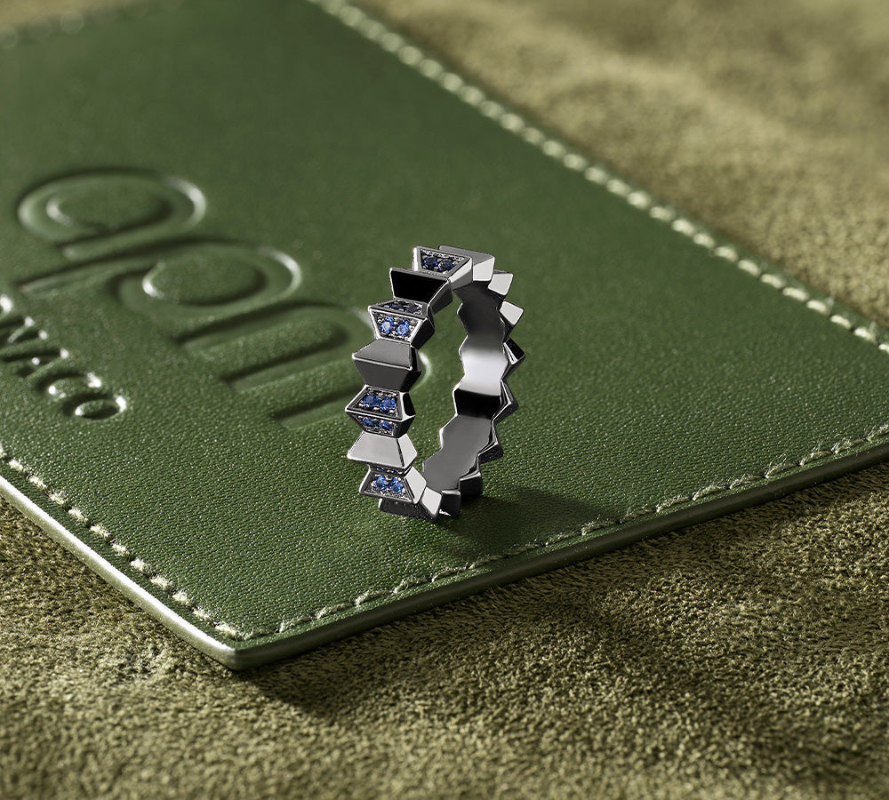 APM MONACO silver ring with blue stones on a green leather surface