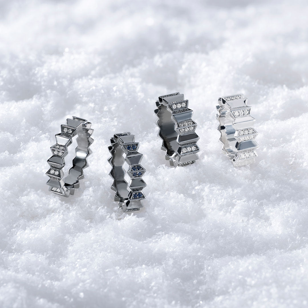 Four APM MONACO silver rings on a white snowy background