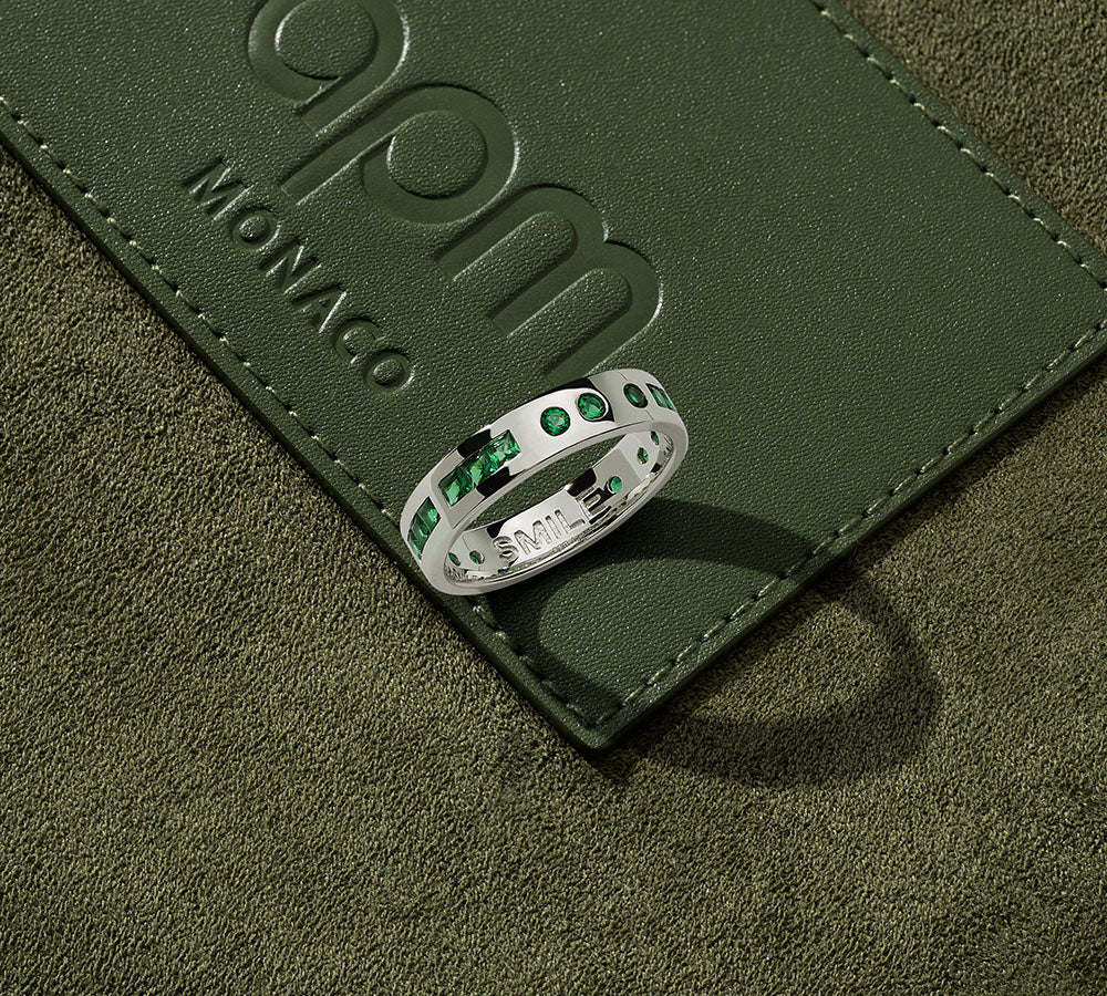 APM MONACO silver ring from morse code collection on a green leather surface with 'APM Monaco' branding.