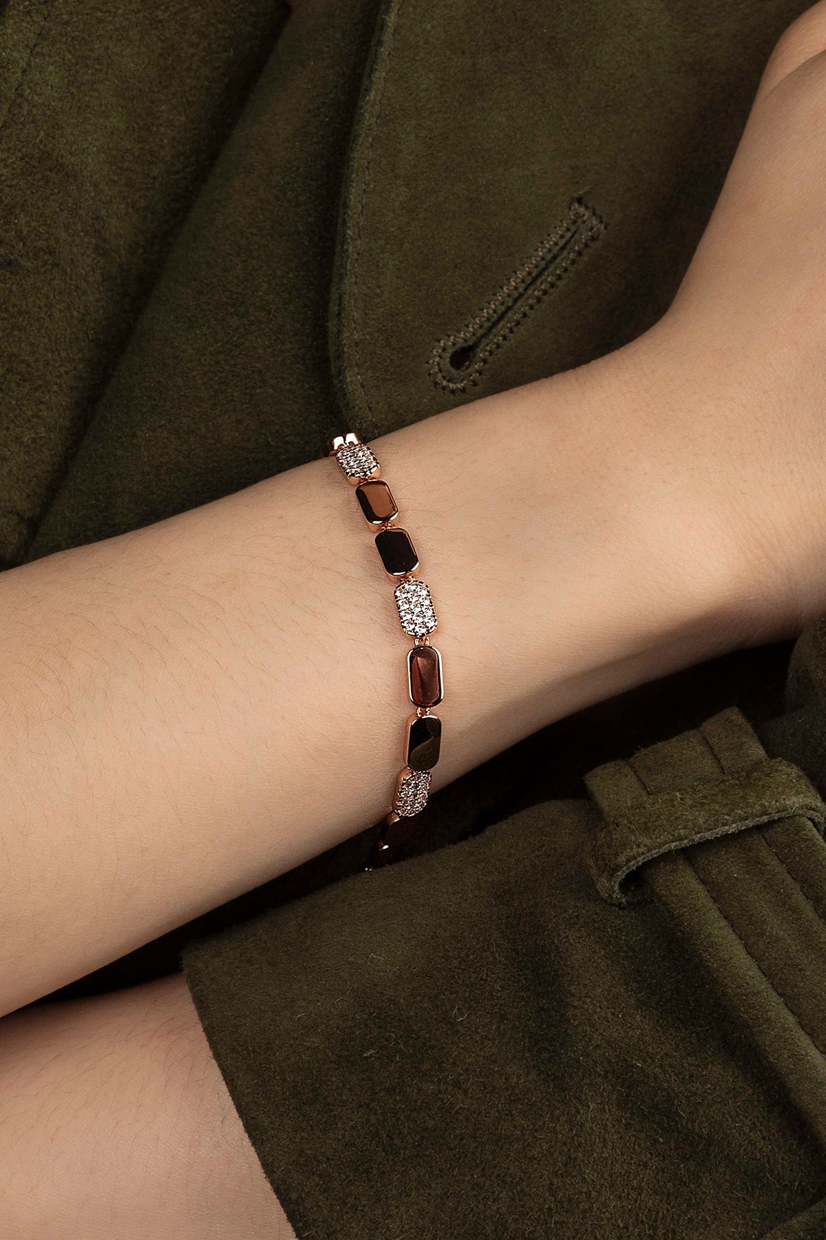 Bracelet with gemstones on a wrist against a dark background