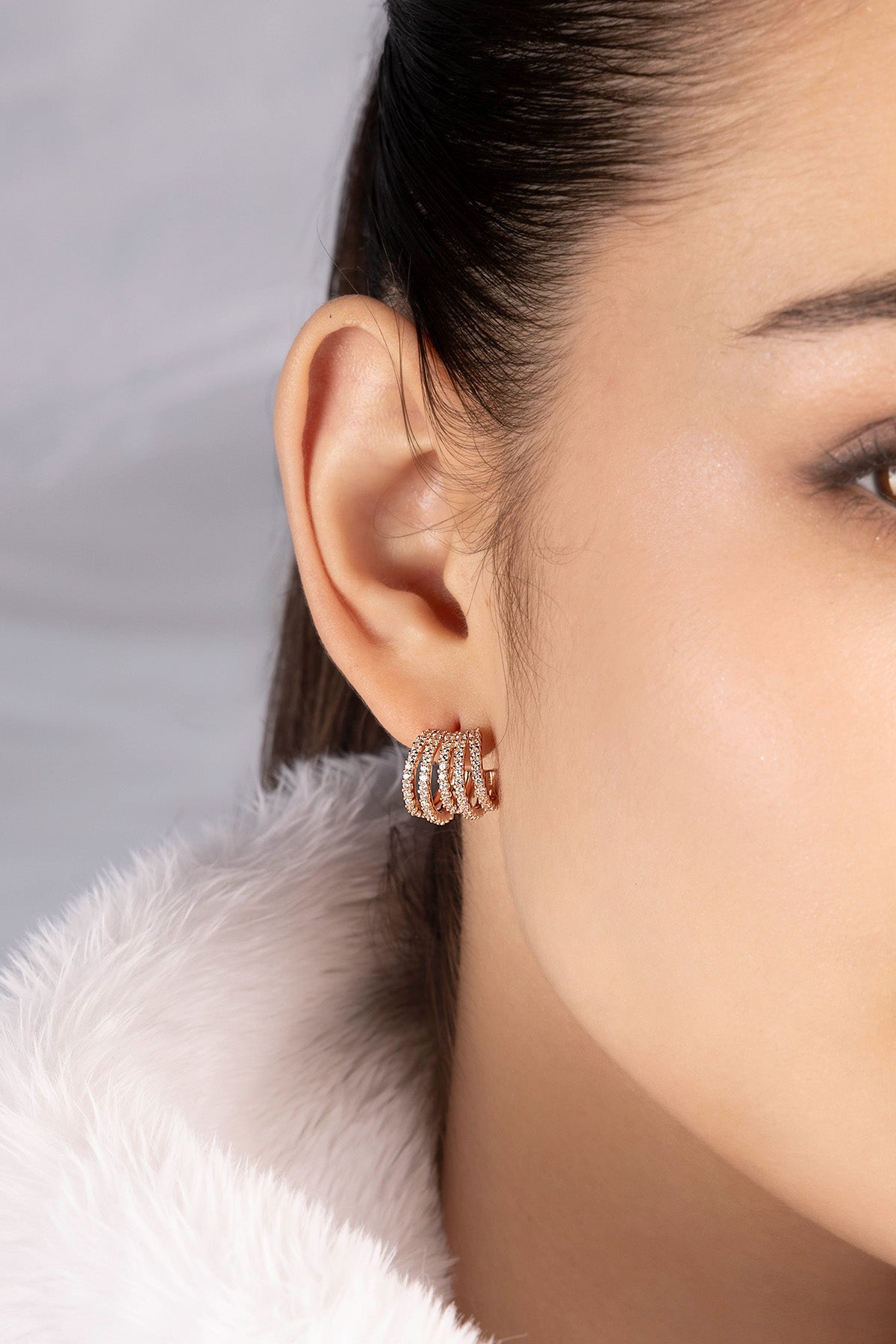 Close-up of a woman wearing APM MONACO earring with five-hoop design
