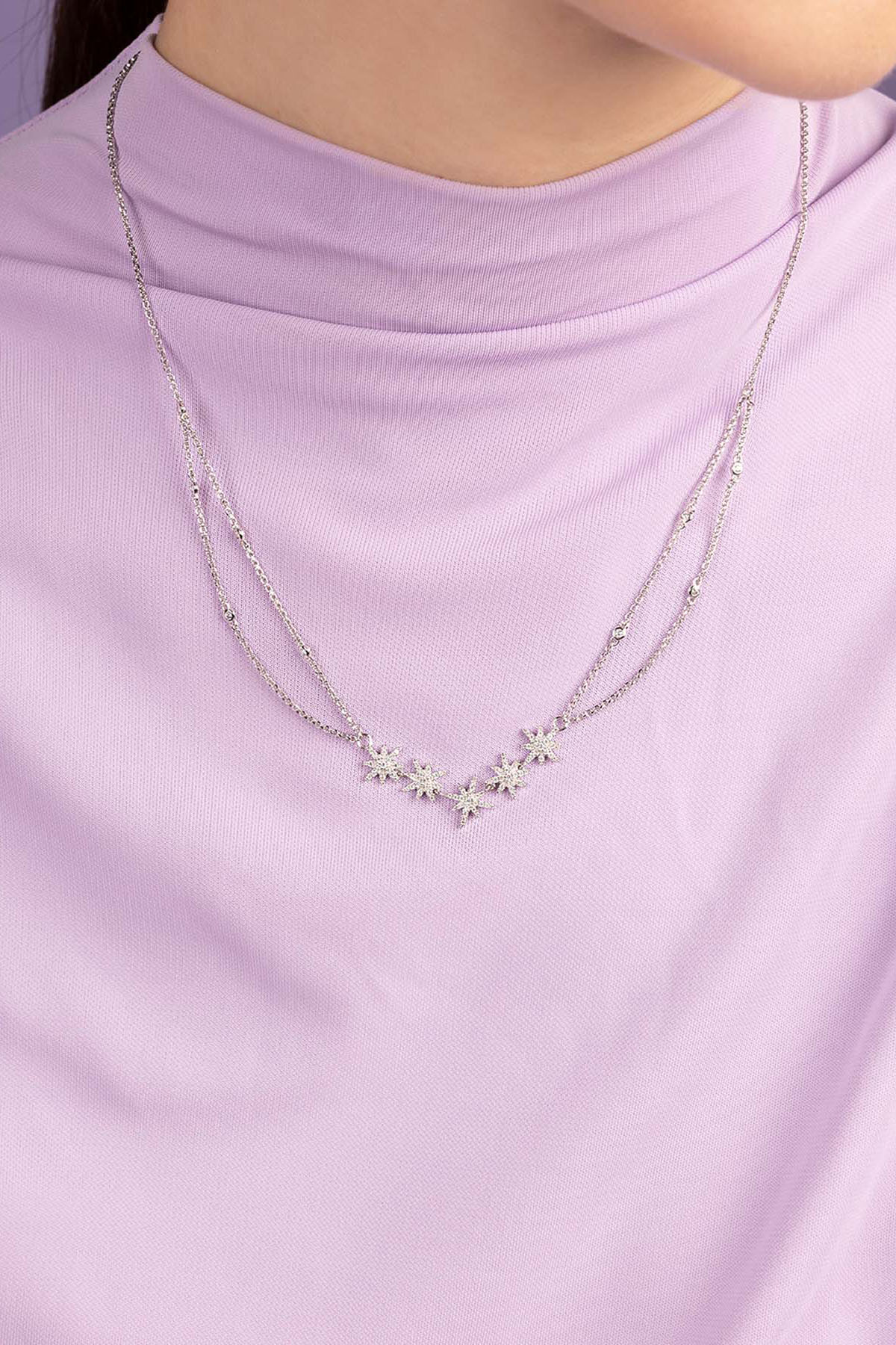 APM MONACO adjustable Necklace with floral pendants on a person wearing a light purple top