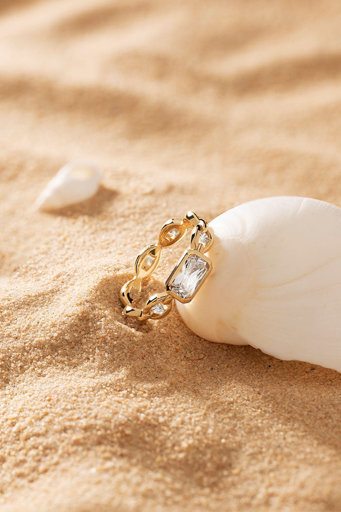 APM Monaco Éclat Chain Ring in Yellow Gold on soft beach