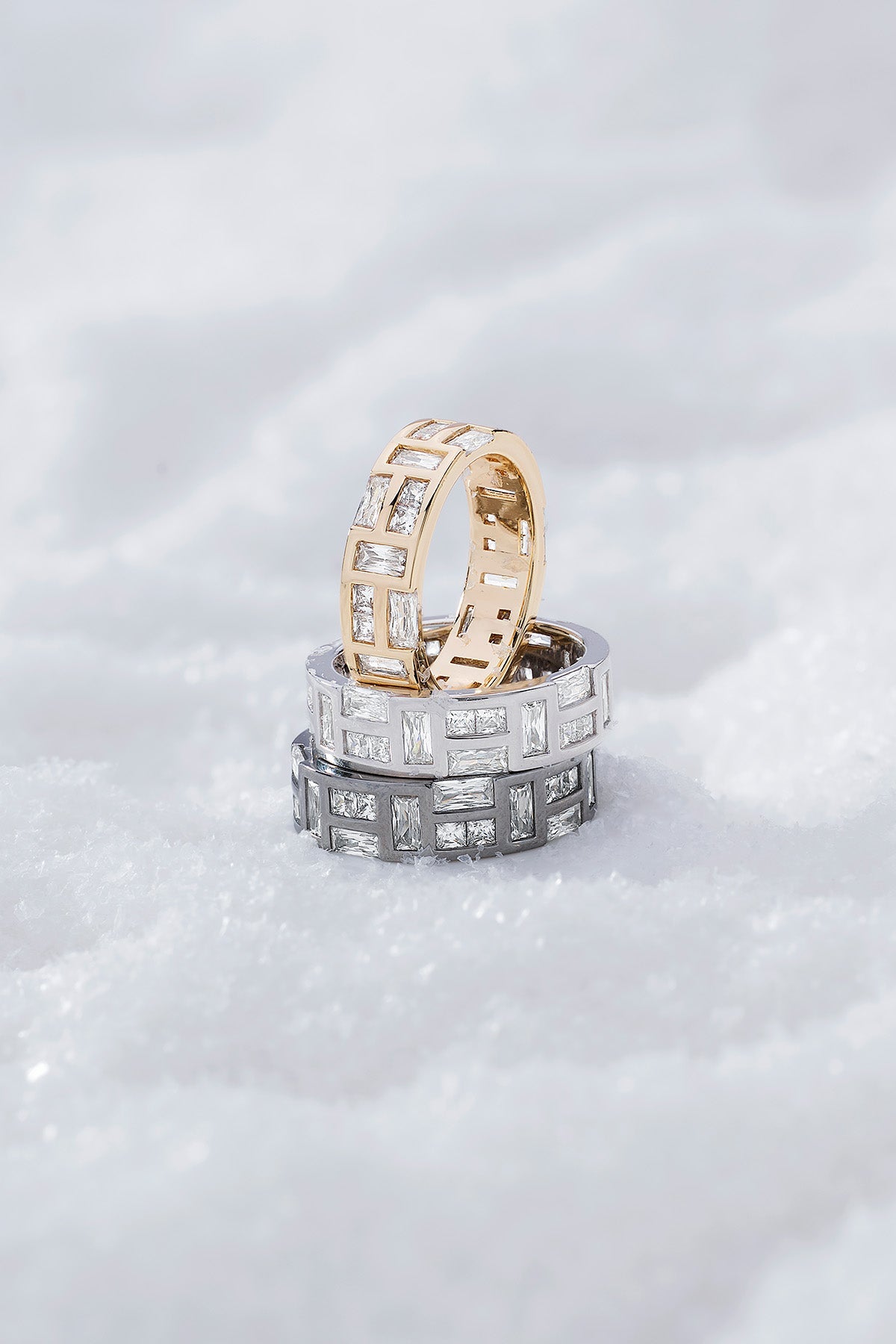 Three labyrinth rings from APM MONACO stacked on a white snowy surface