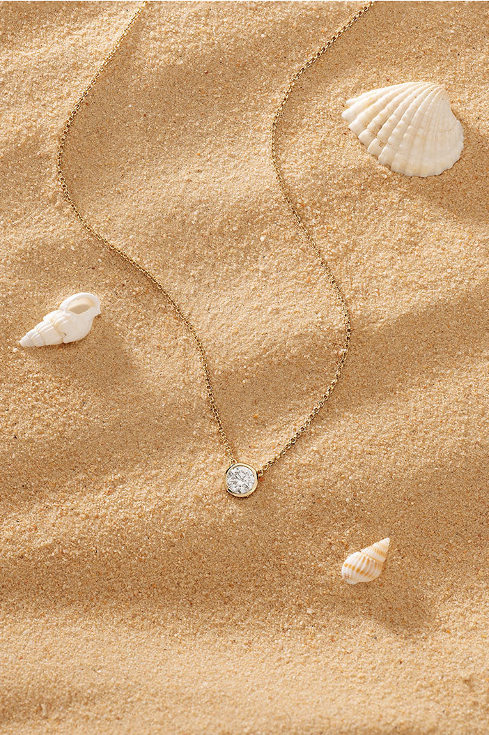 APM Monaco Éclat Adjustable Necklace in Yellow Gold on soft beach