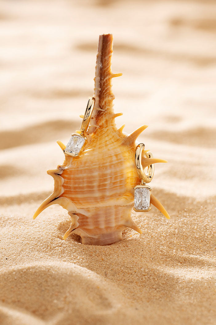 APM Monaco Éclat Hoop Earrings in Yellow Gold on soft beach