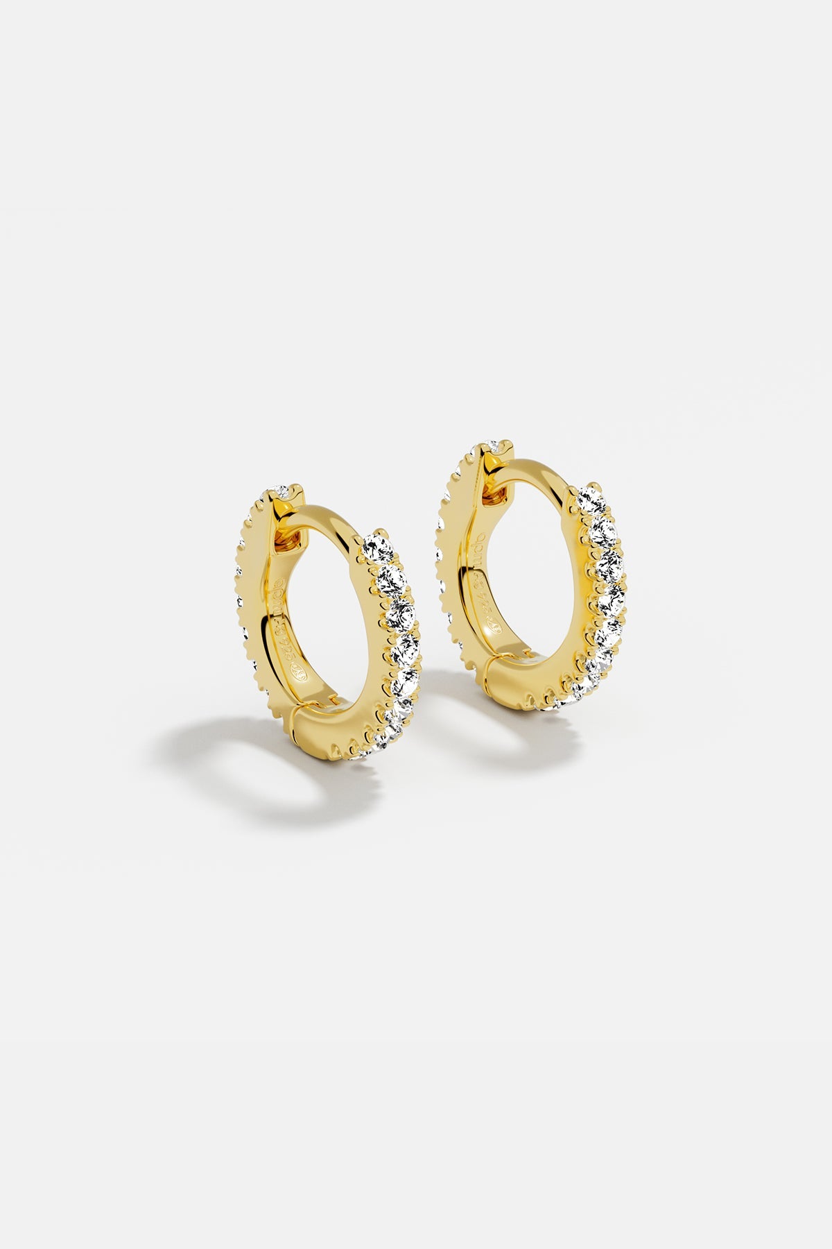 Earrings APM Monaco: yellow gold huggie hoops with white cubic zirconia.