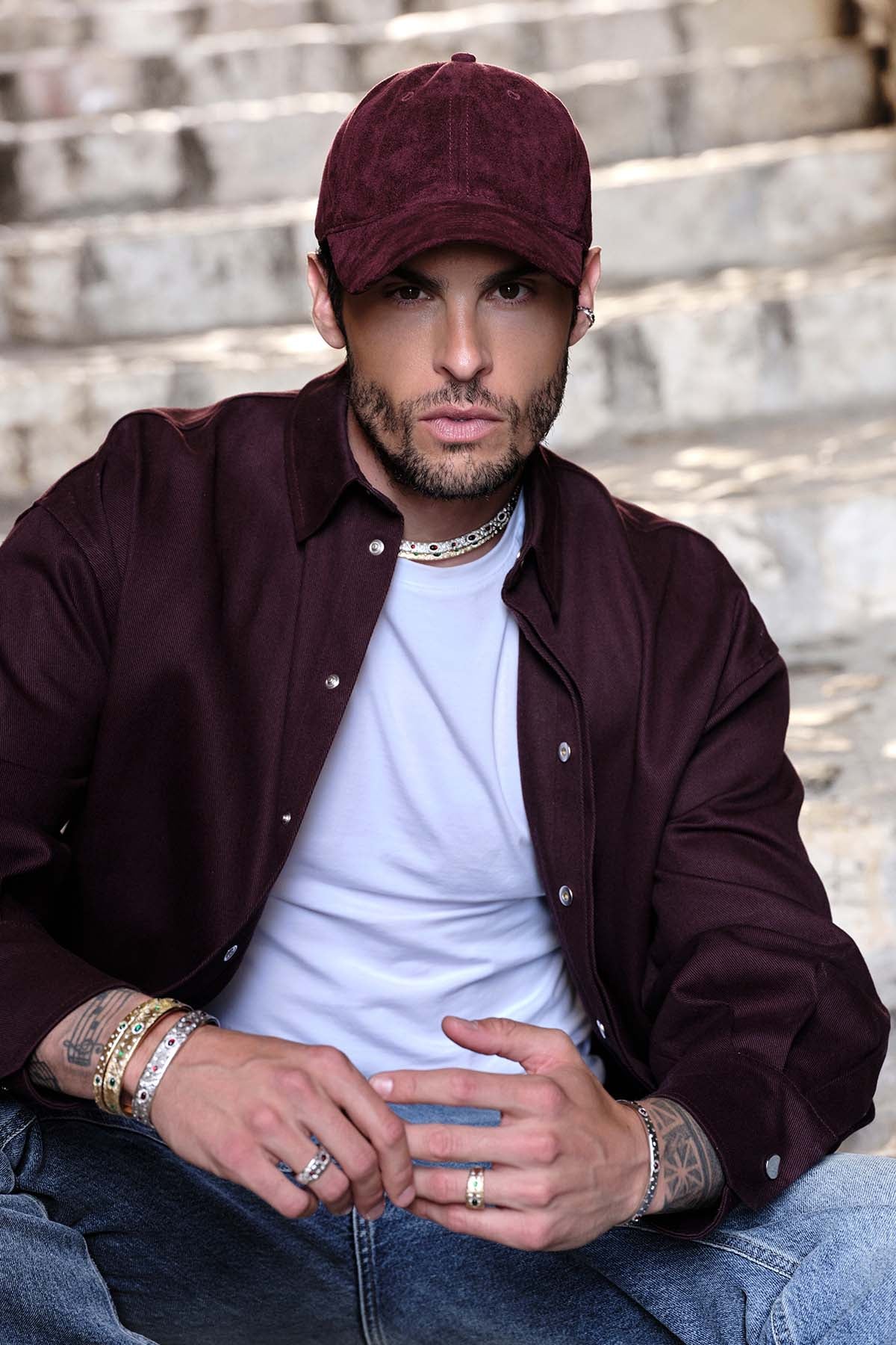 Man wearing APM Monaco stacked bracelets and rings, effortless urban charisma in rhodium finish.