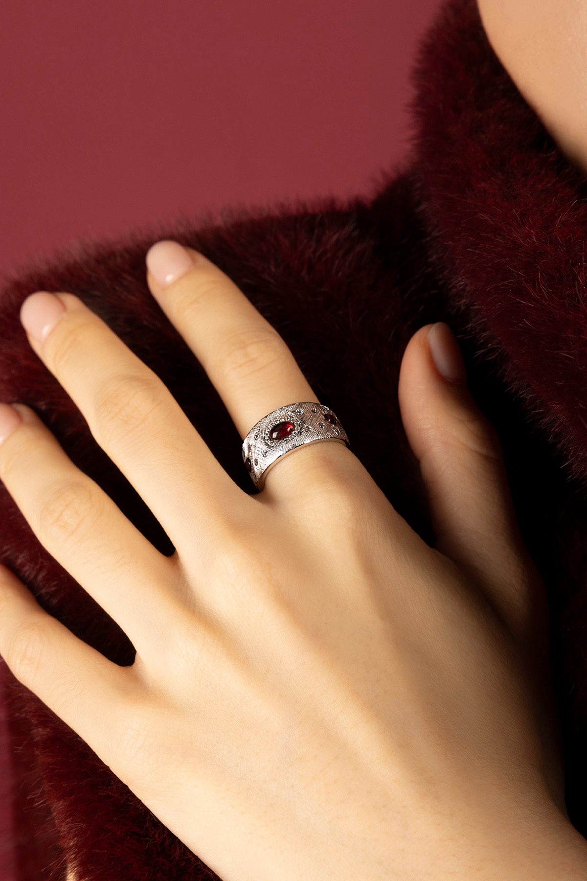 Woman wearing APM Monaco ring, a bold whisper of crimson elegance.