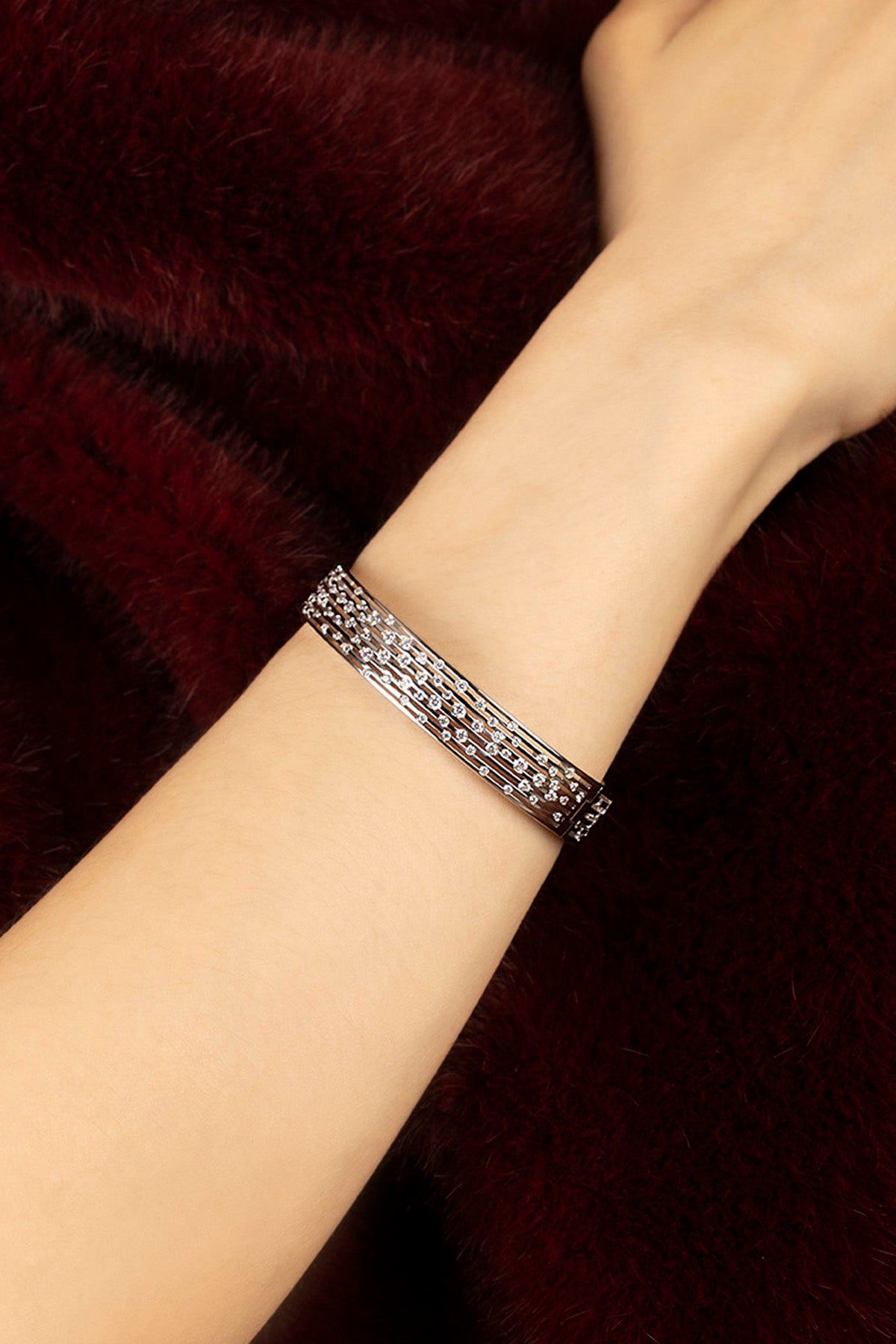 Woman wearing APM Bracelet in rhodium finish, a shimmering whisper of modern elegance.