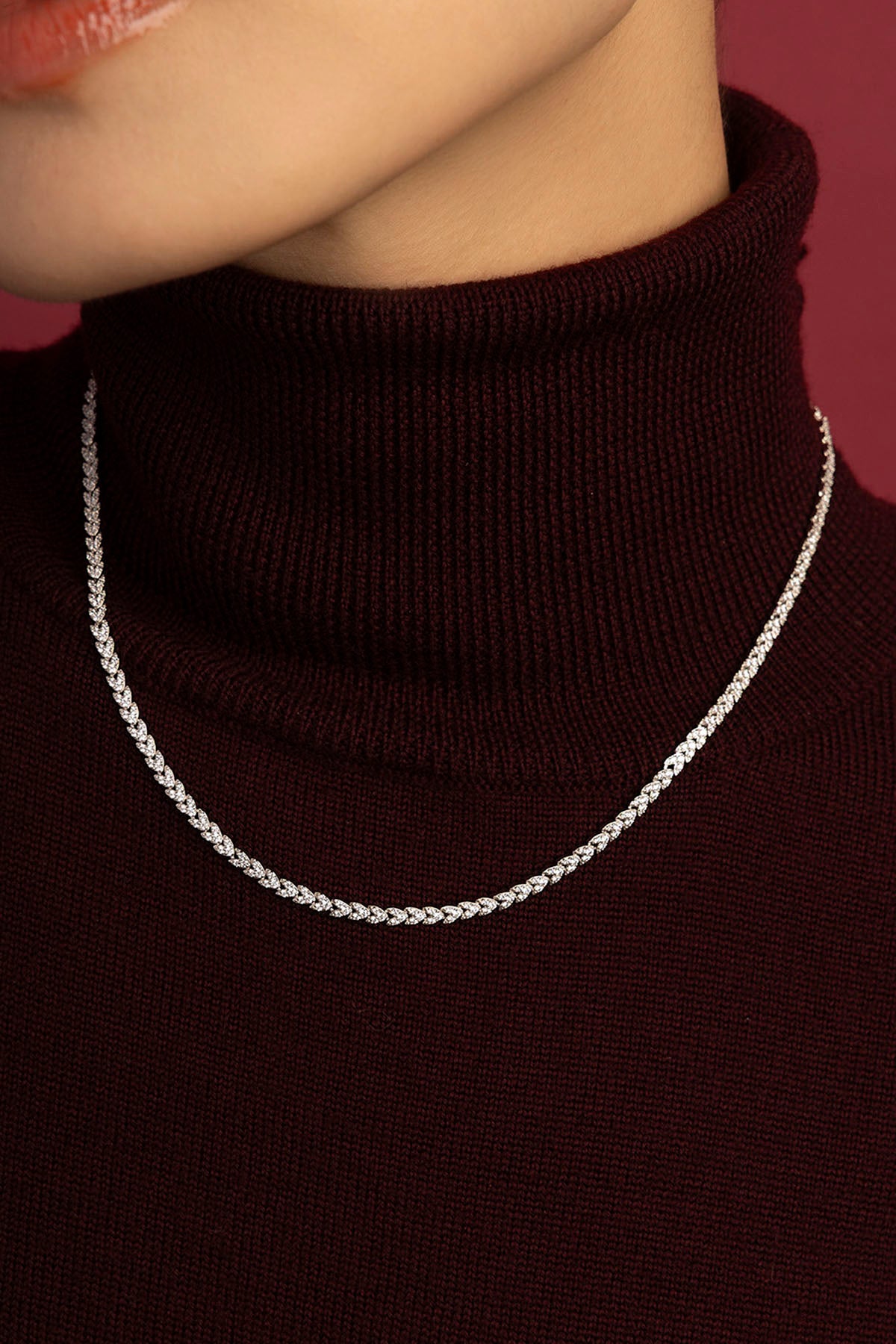 Woman wearing APM Monaco chain necklace, a shimmering line of quiet confidence.