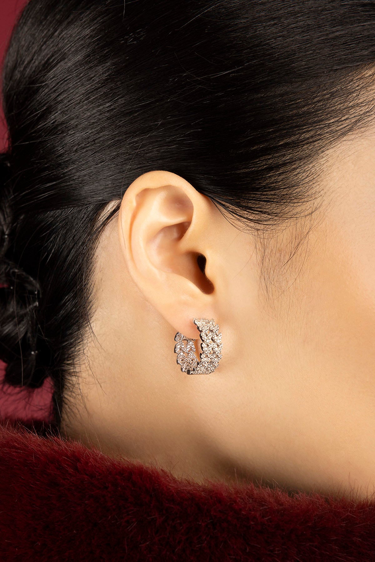 Woman wearing APM hoop earrings, a shimmering whisper of modern elegance.