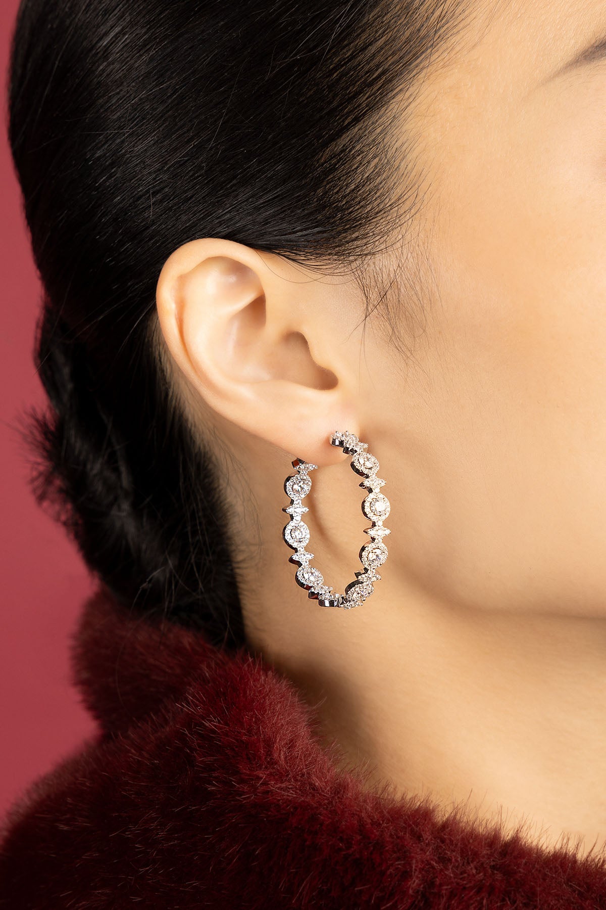 Woman wearing APM hoop earrings, a sparkling statement of modern elegance.