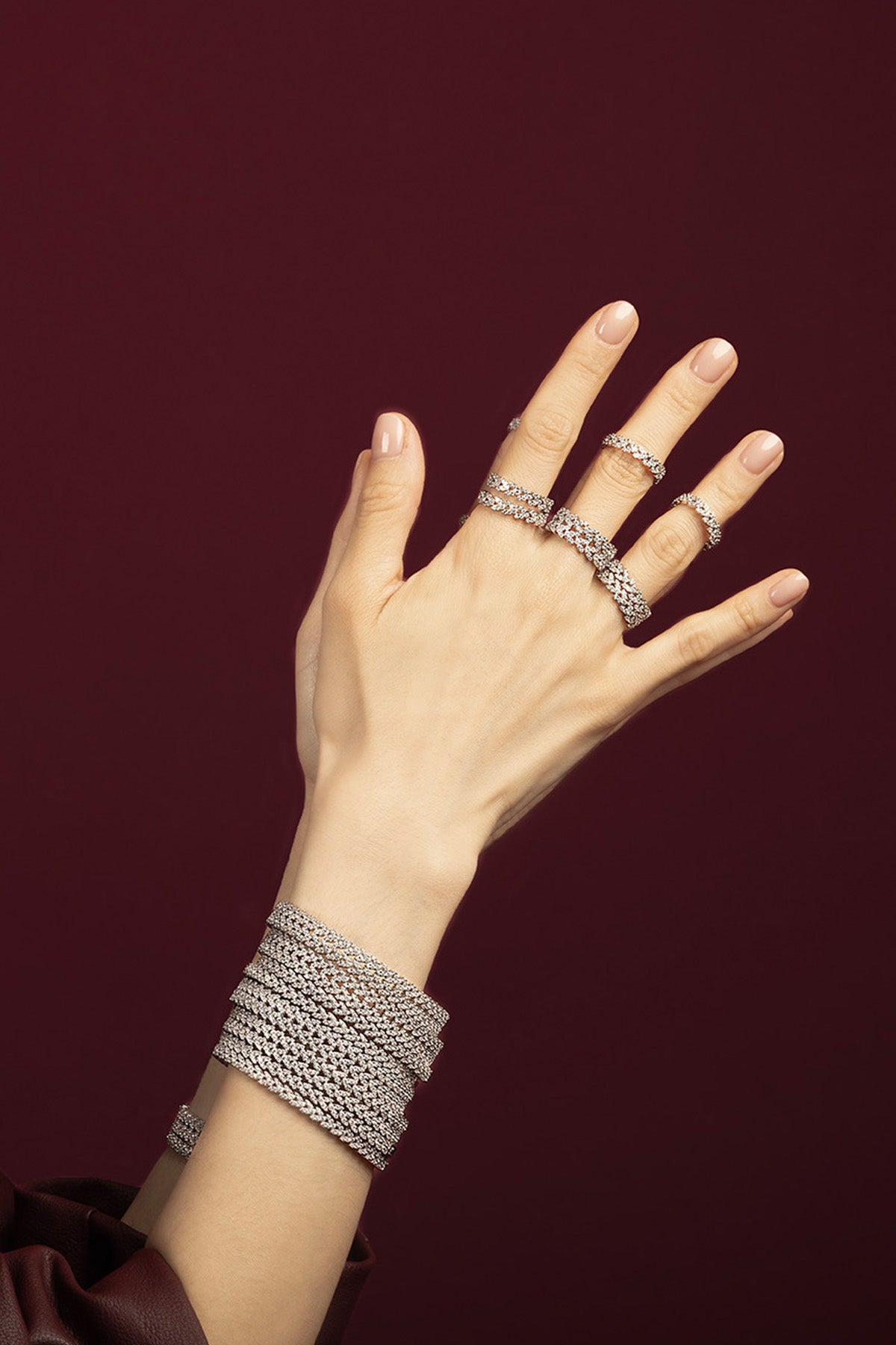 Woman wearing APM Monaco bracelets and rings, a shimmering cascade of quiet glamour.