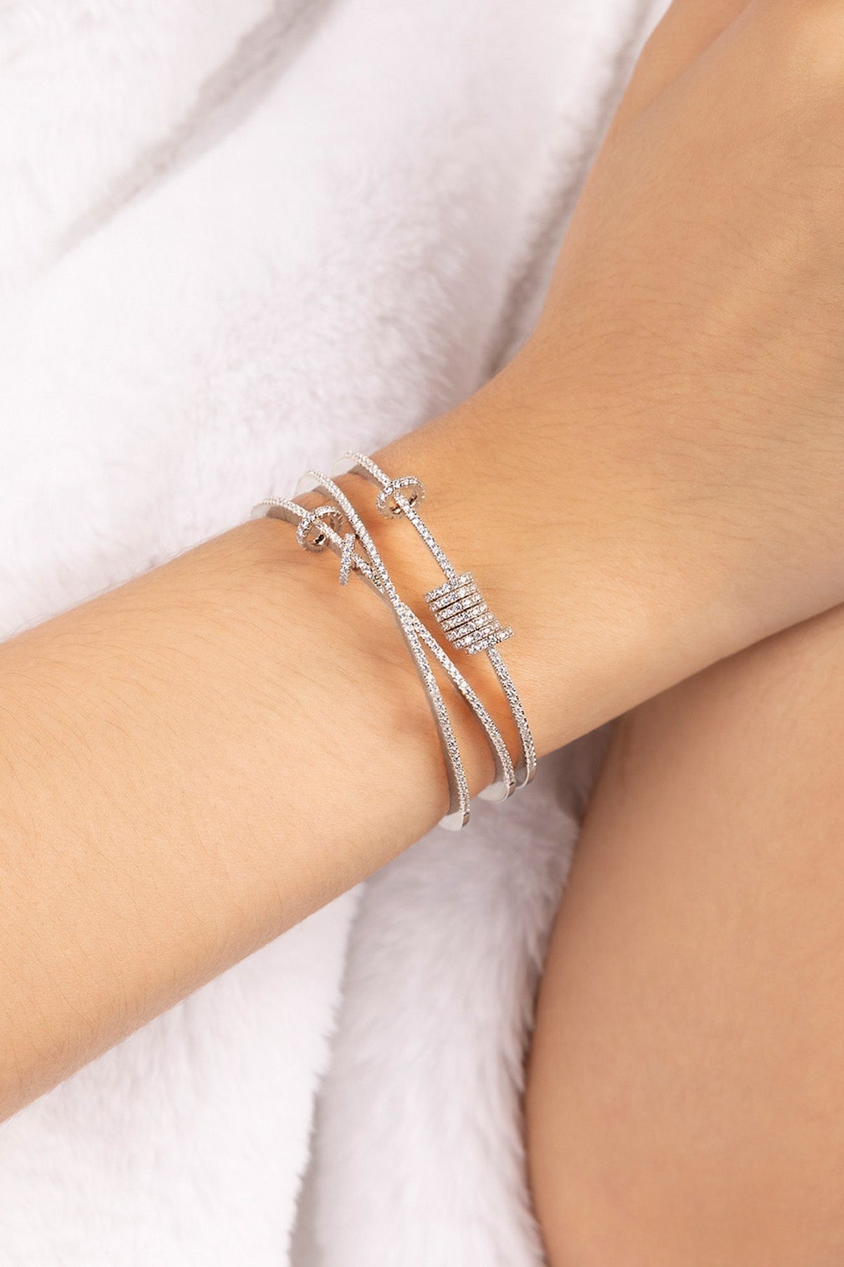 Silver triple cuff with sliding design on a model's wrist with a white background