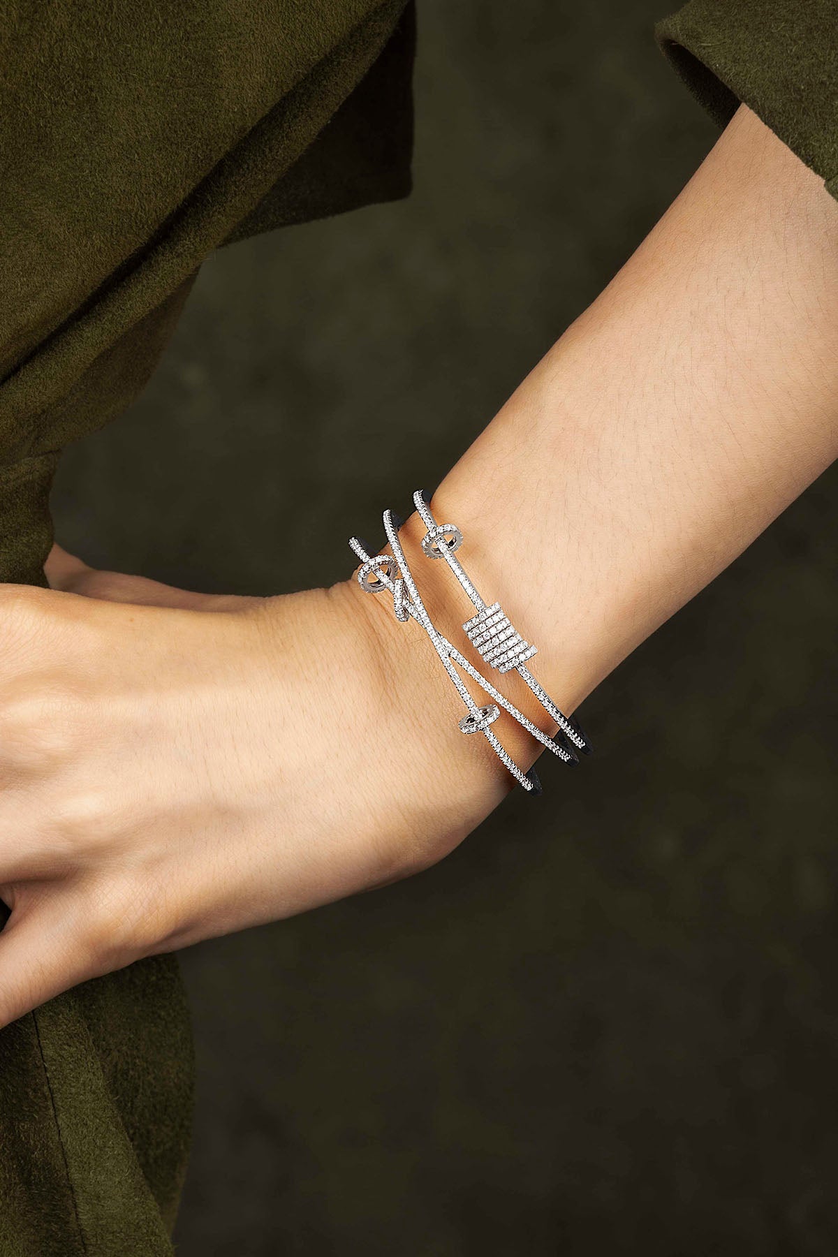 Silver bracelet on a wrist with a dark background