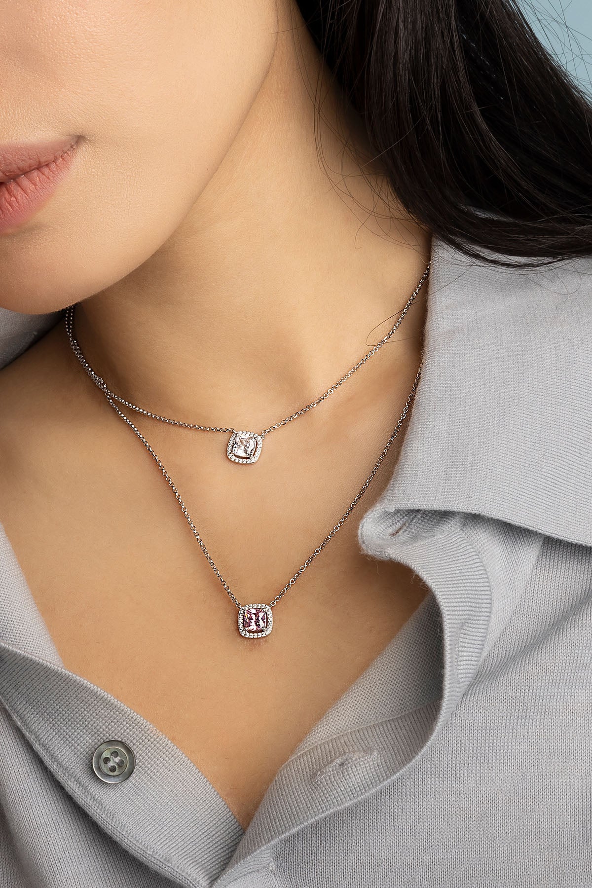 Close-up of a model wearing silver necklace with small square stone pendants