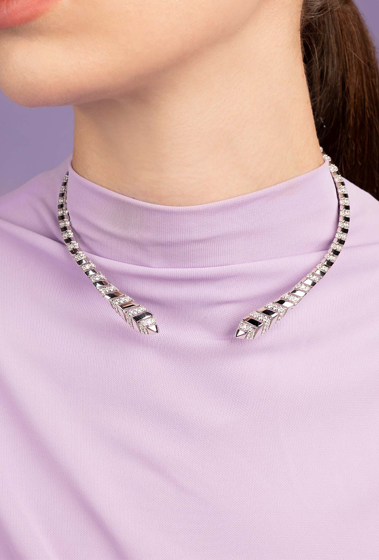 APM MONACO kaa choker in silver on a person wearing a light purple top against a purple background