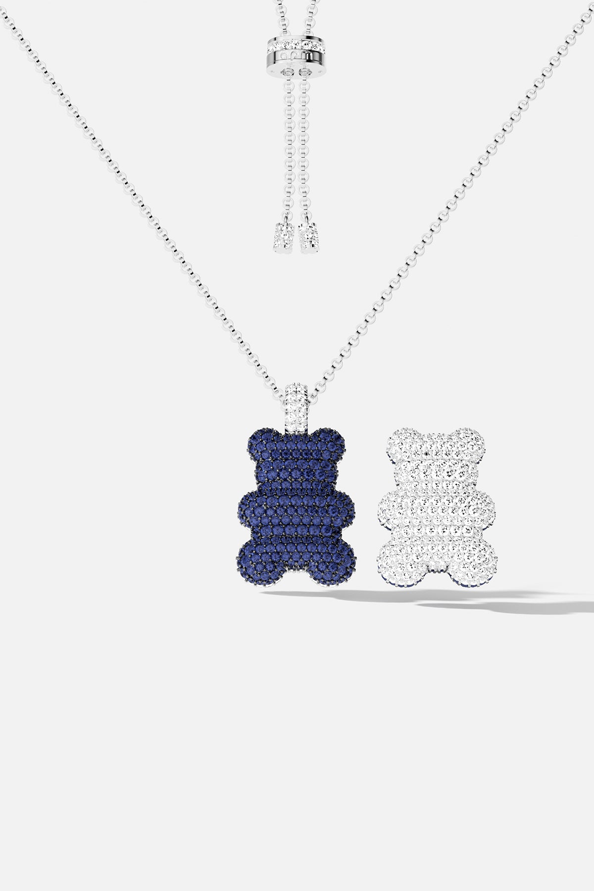 Blue teddy bear pavé pendant necklace with white teddy bear pavé pendant against a white background