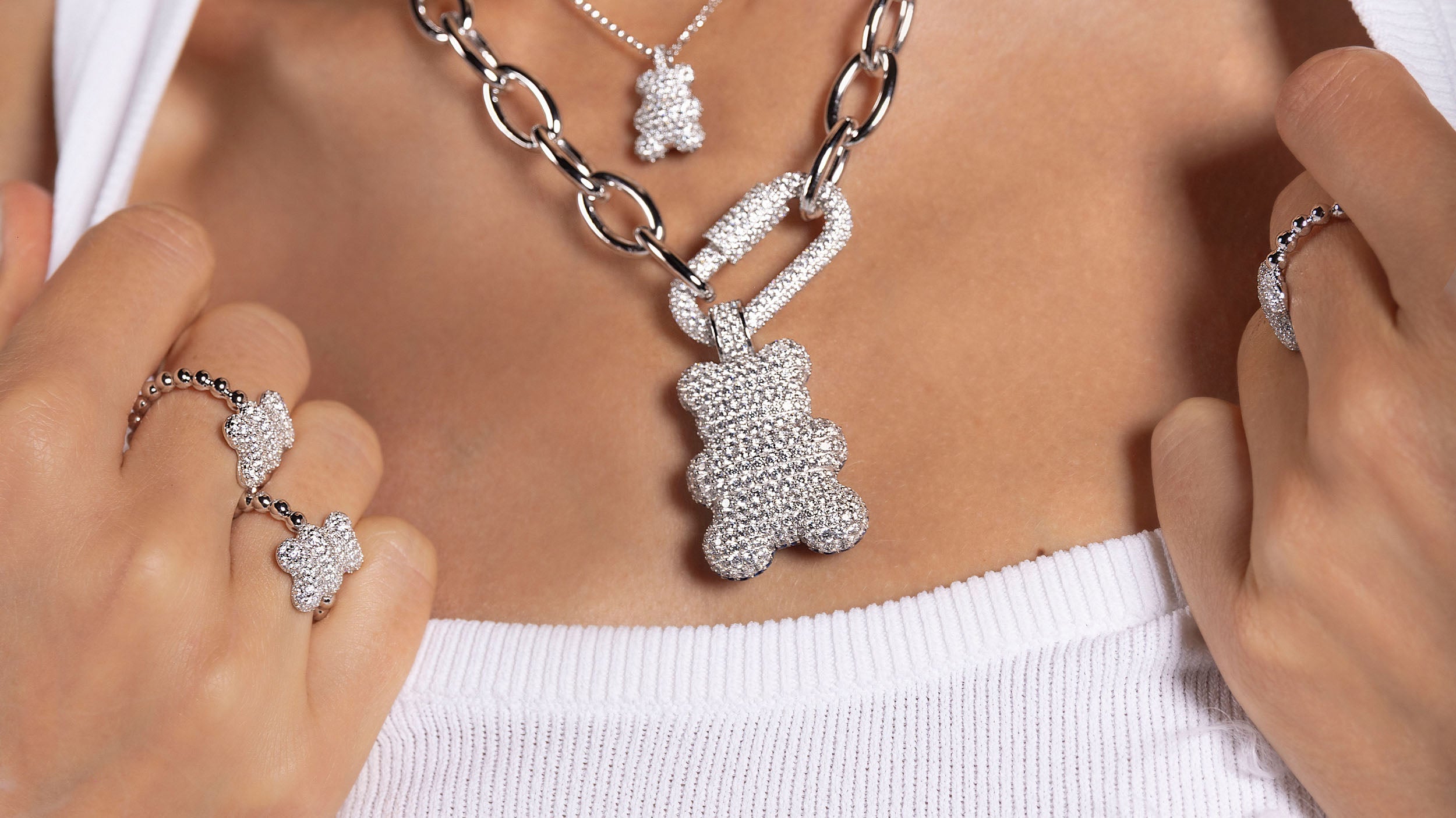 APM MONACO jewelry set with bear-shaped pendants on a white top