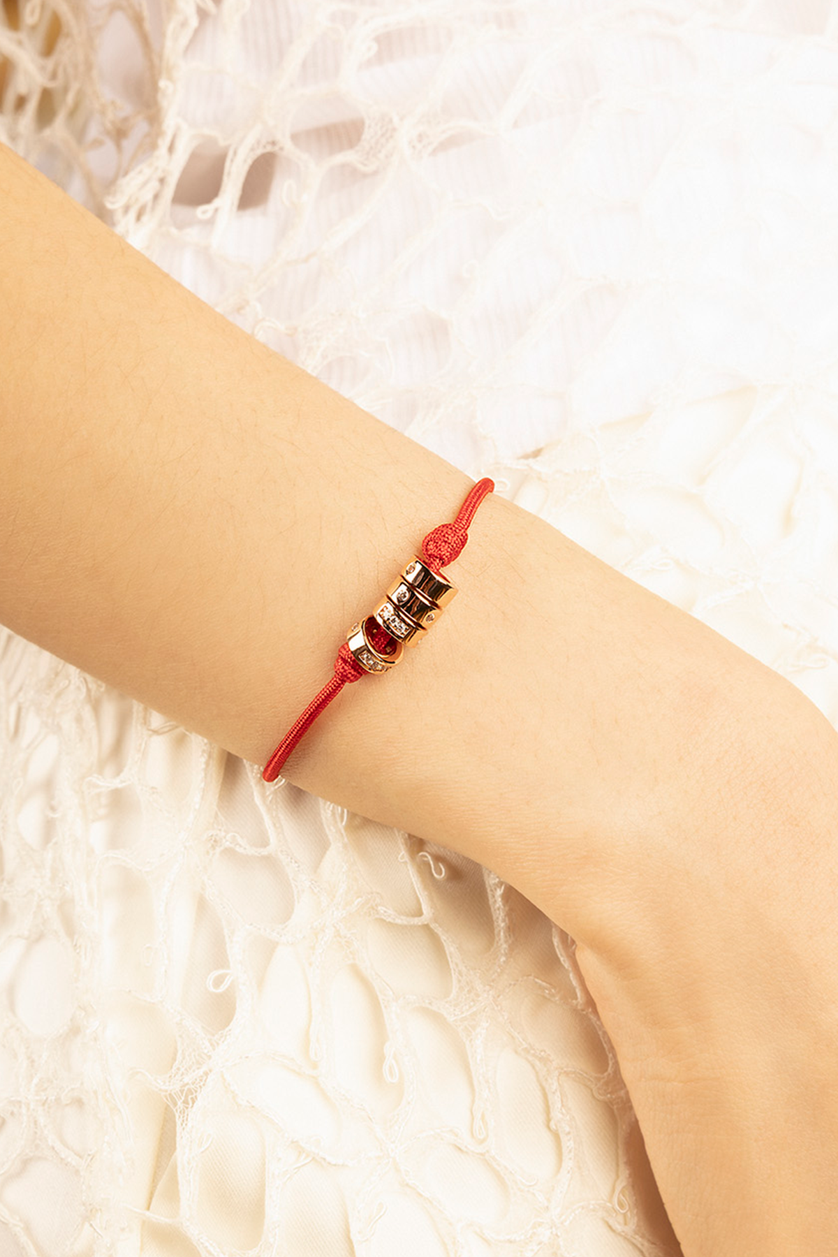 APM Monaco LOVE Morse Code String Adjustable Bracelet in red and yellow gold worn on hand