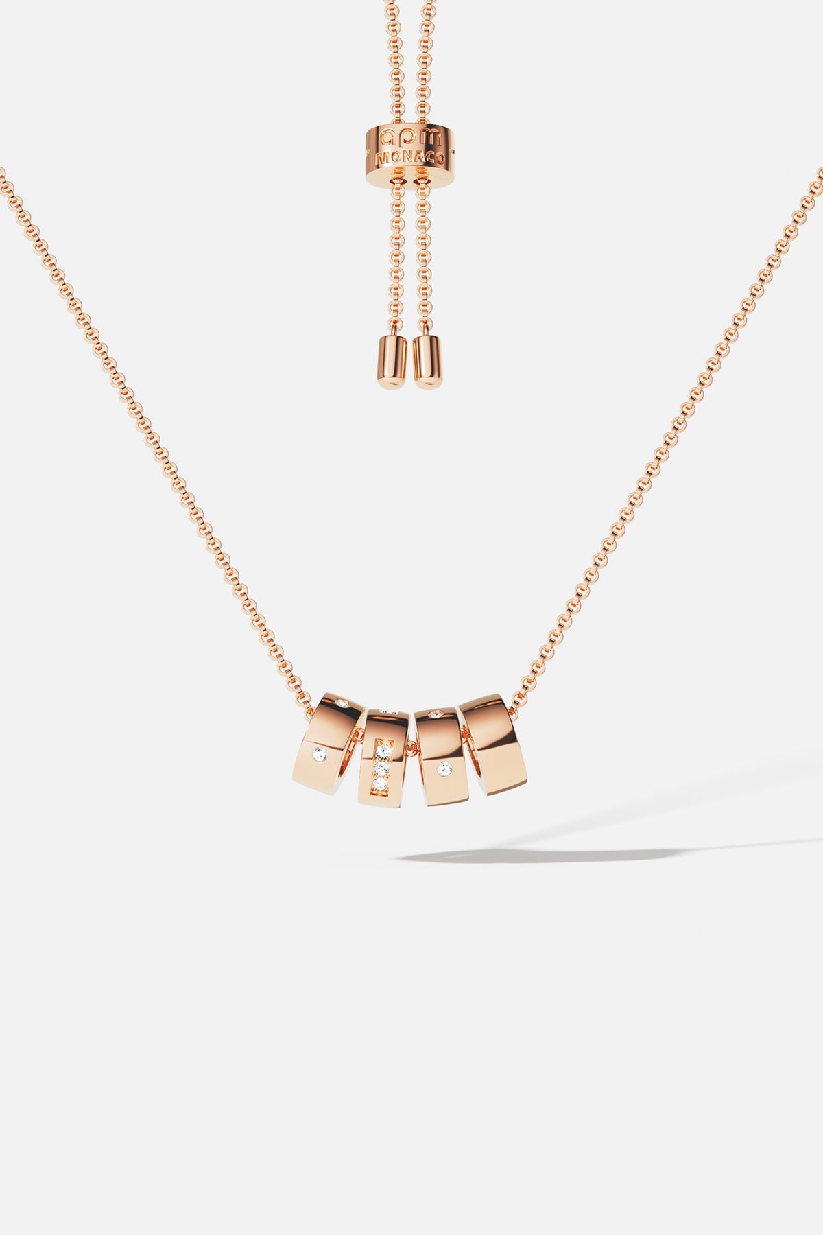 Necklaces APM Monaco: Rose gold adjustable necklace with square charms, some encrusted with crystals, suspended from a delicate chain.