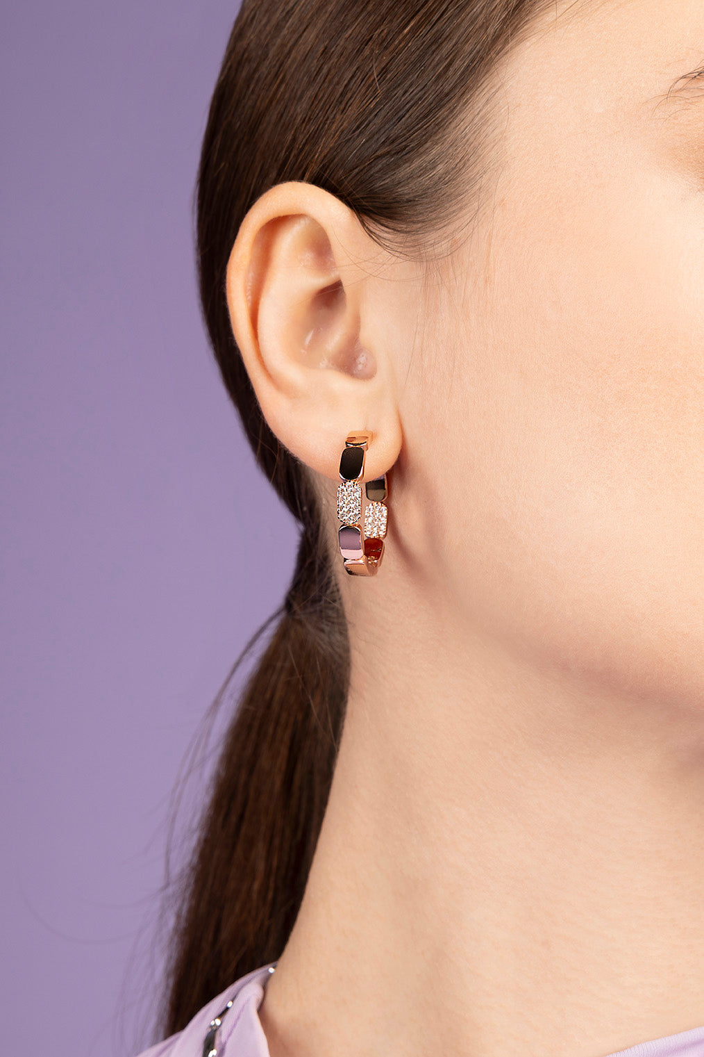 APM MONACO dainty rose gold hoop earrings on purple background