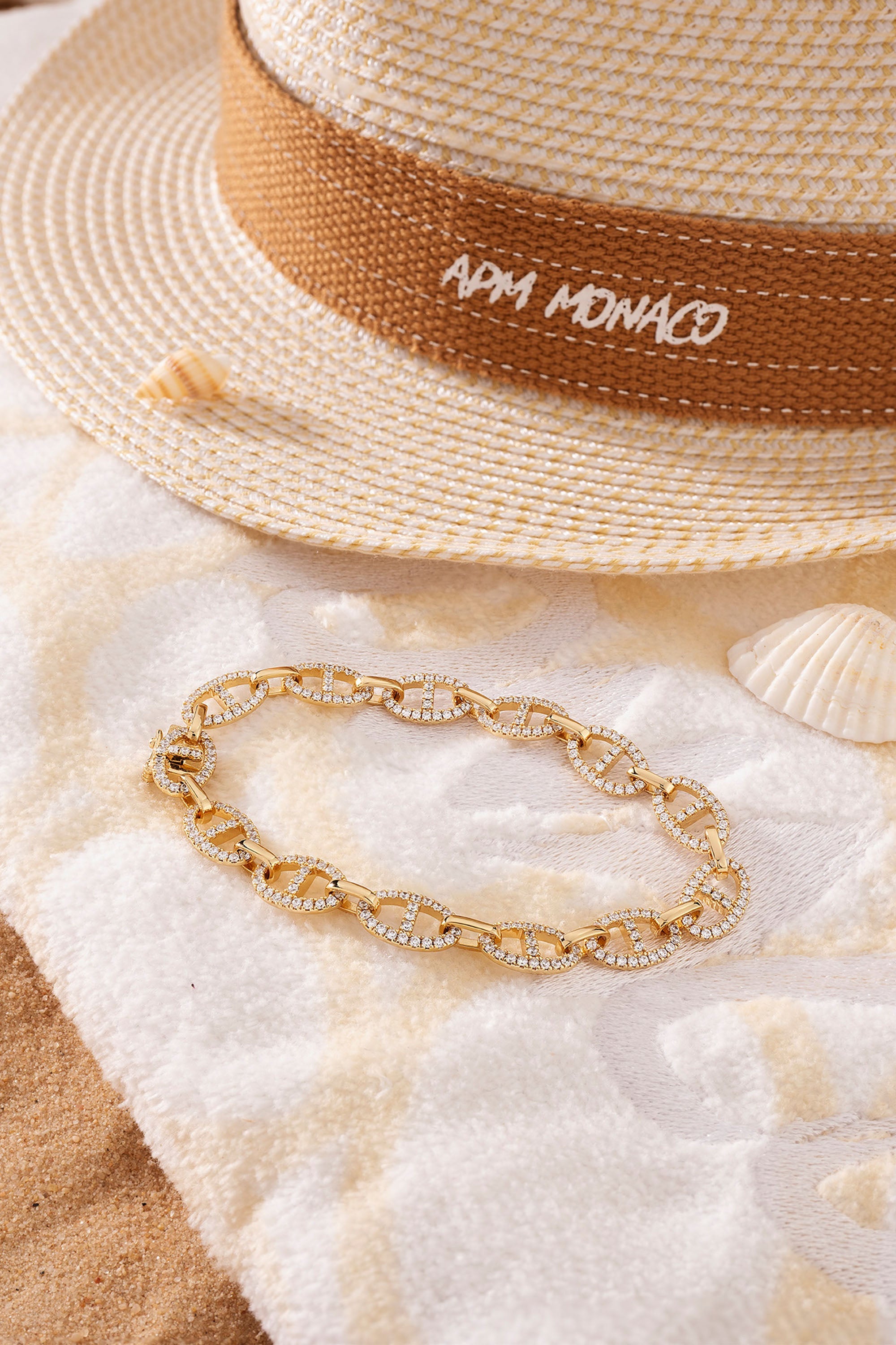 Gold-plated Marine chain necklace with pavé details on beach towel with straw hat and shells
